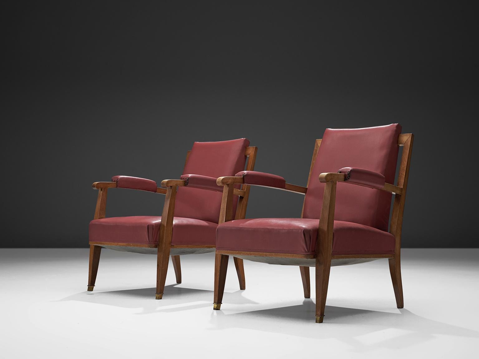 Jules Leleu, armchairs, pink leatherette, brass and stained beech, France, 1957

This set of two elegant armchairs in wood and pink-purple leatherette upholstery, and are made out of solid oak. The high tapered wooden legs provide an open look to