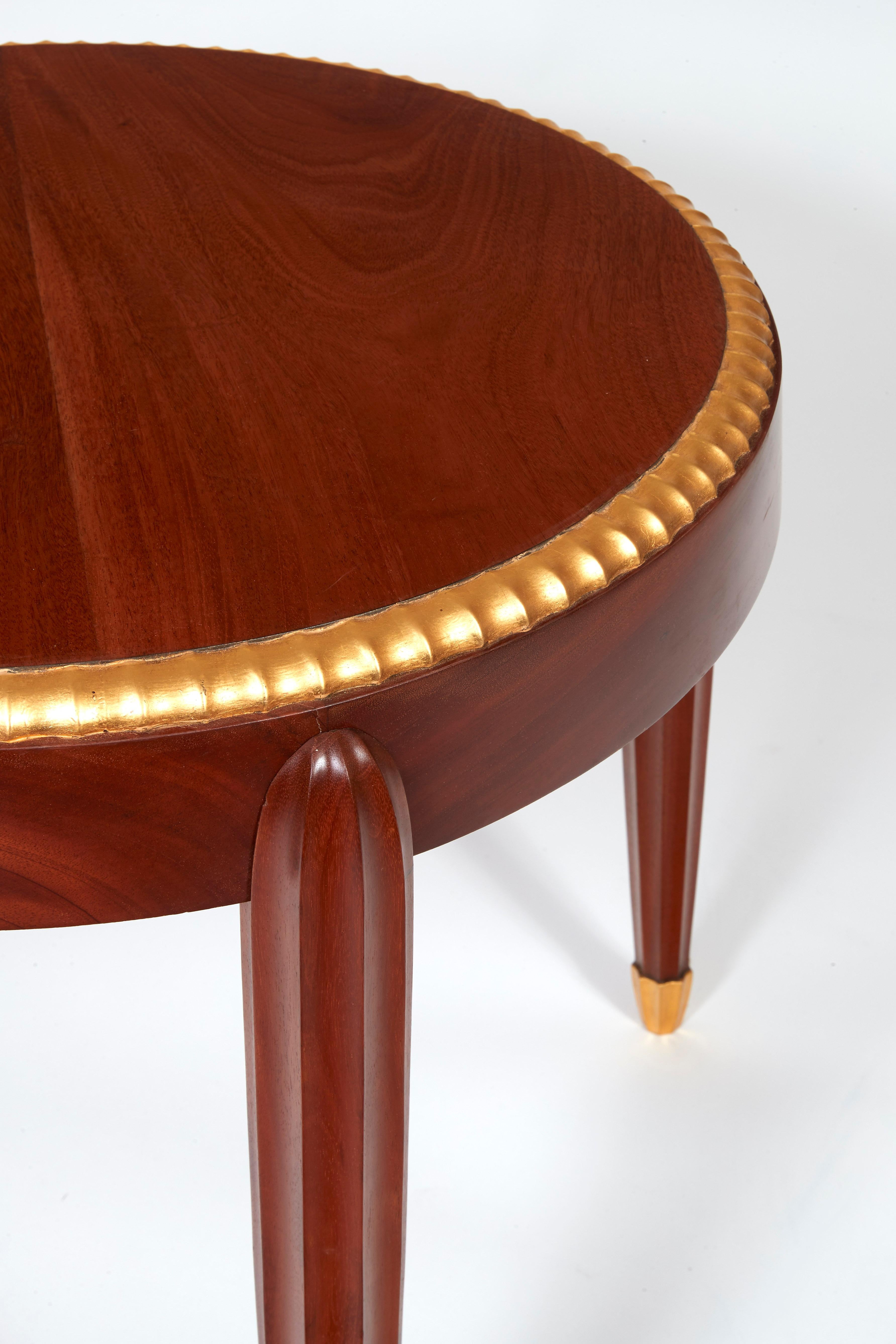Pedestal table, circa 1925

Pedestal table in mahogany wood with a circular tray enhanced by a notched frieze. Four overlapped tapered notched legs with sheathed spinning top-shaped foot. Notched frieze and foot enhanced by golden