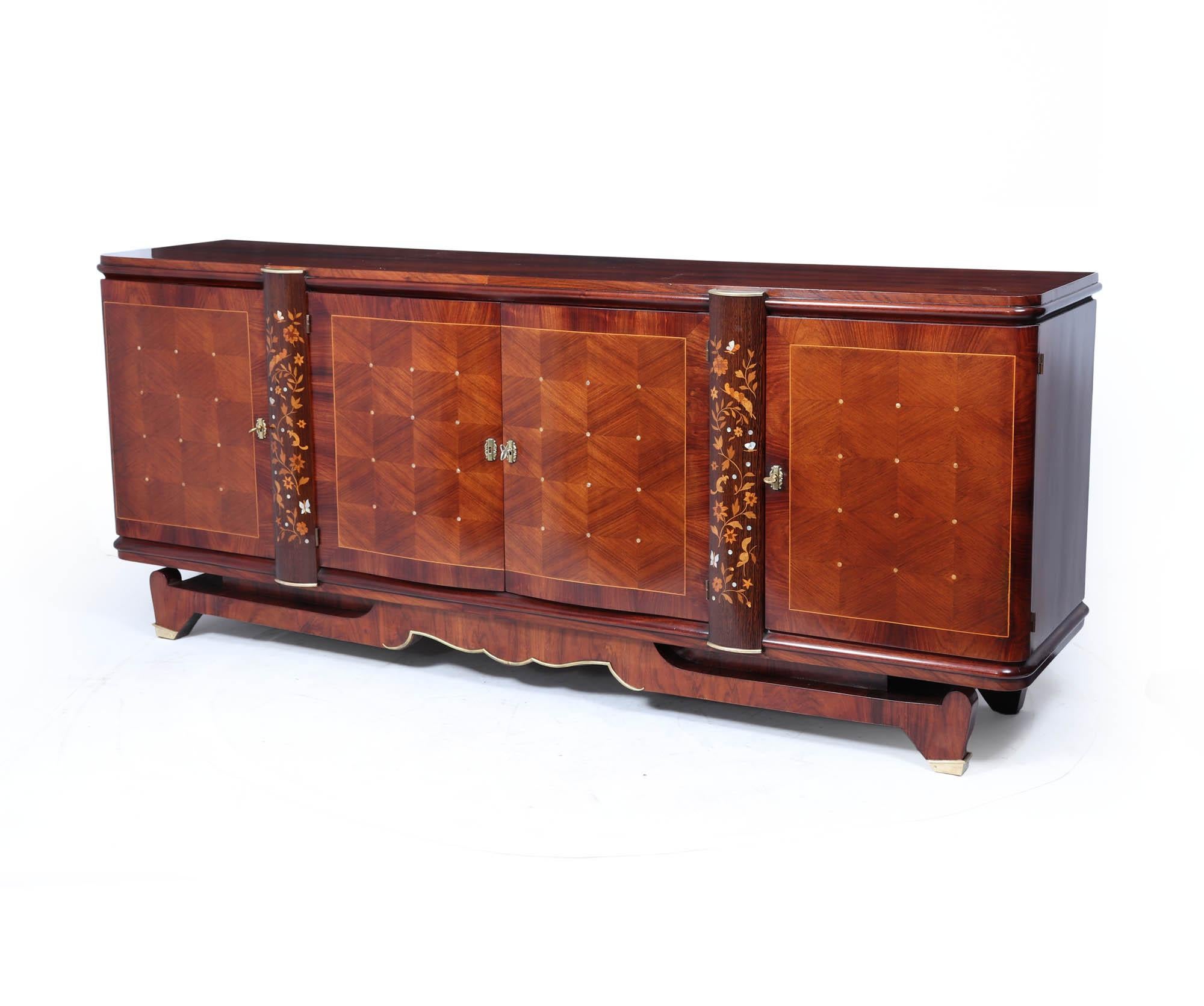 A stunning and sophisticated Art Deco sideboard by renowned French designer Jules Leleu, crafted in rosewood and palmwood with intricate floral and butterfly inlay. Dating from the 1940s, this piece epitomises Leleu’s mastery of luxurious materials
