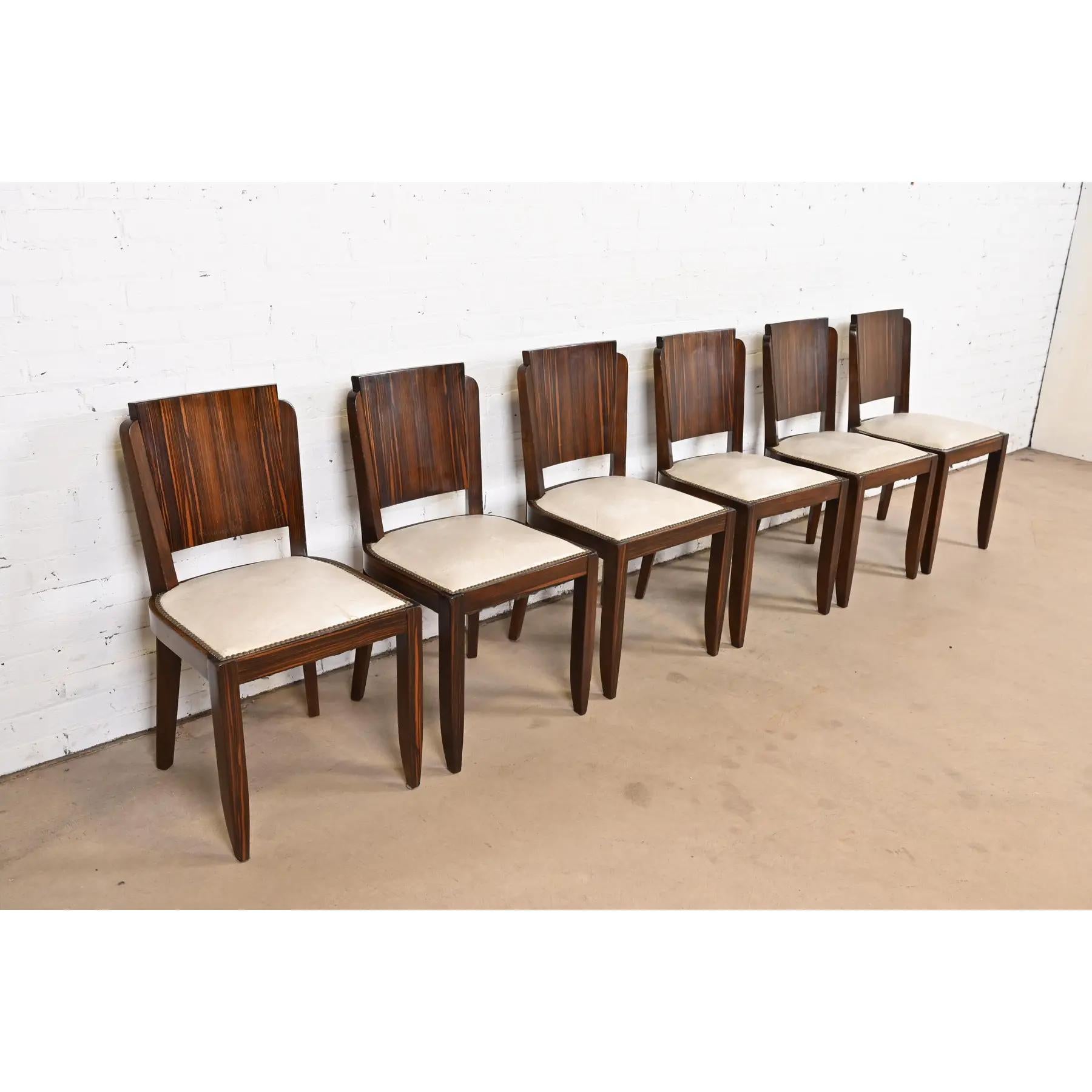 Uno splendido set di sei sedie da pranzo d'epoca Art Déco

Alla maniera di Jules Leleu

Francia, circa anni '30

In legno di ebano Macassar, con sedili imbottiti con borchie in ottone.

Misure: 17,5