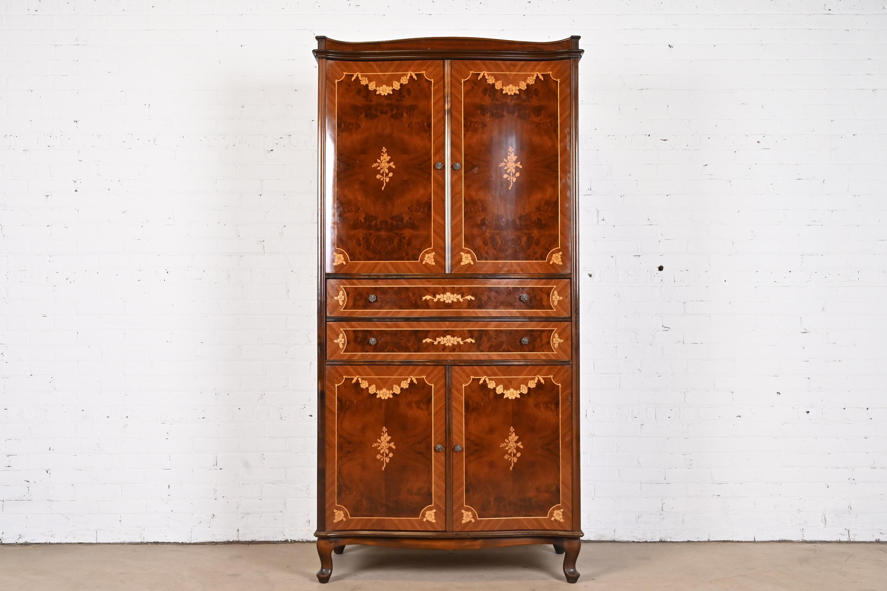 A gorgeous French Continental style armoire dresser or gentleman's chest

In the style of Jules Leleu

Hungary, circa 1940s

Book-matched burled mahogany, with satinwood string inlay and floral marquetry, and original brass