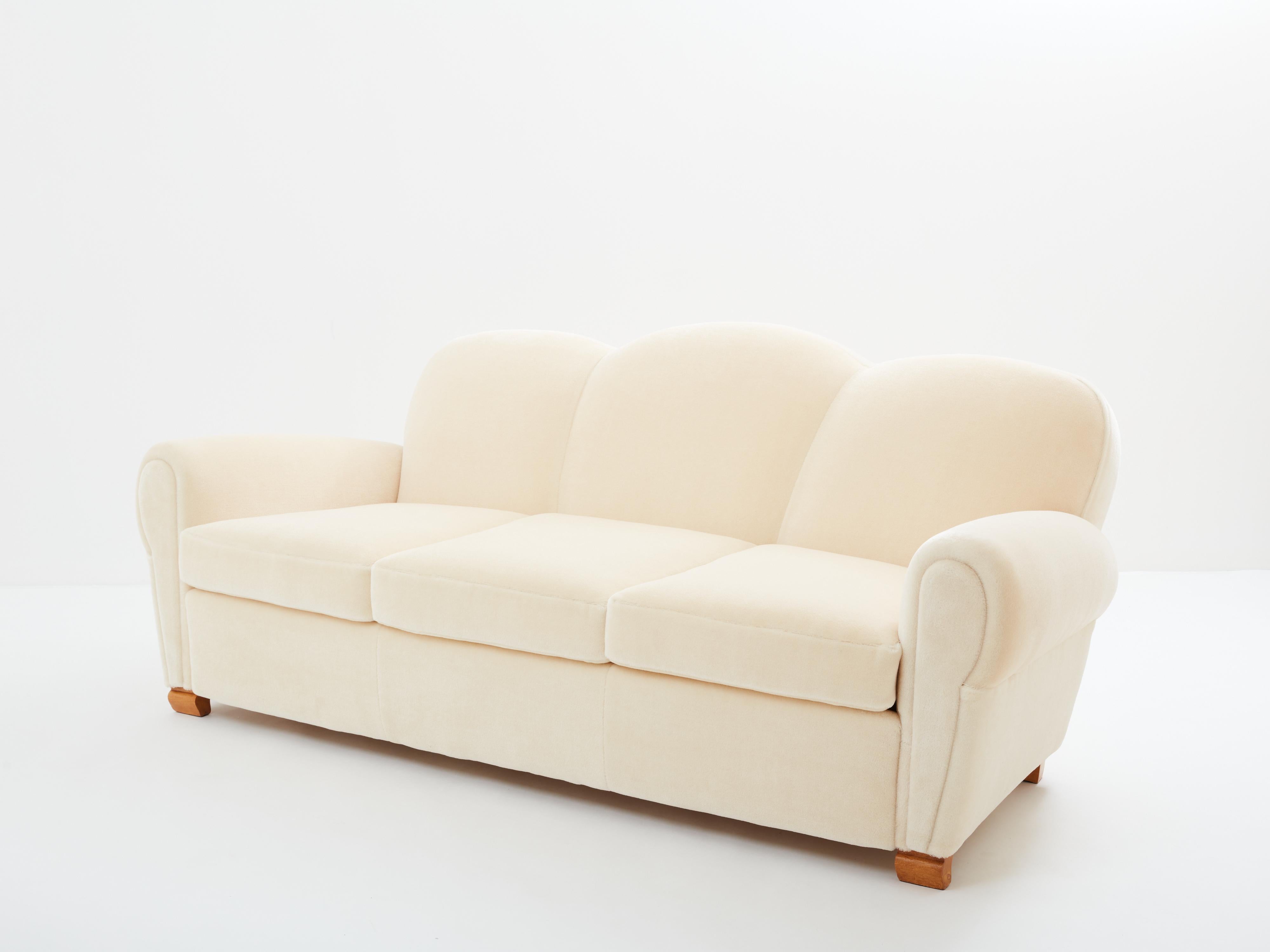 This beautiful sofa designed by Jules Leleu around 1945 embodies the smooth lines of the art deco living room sets that came on the market in the early 1930s. The smooth and round lines are a thing of beauty, finished with curved oak feet, one of