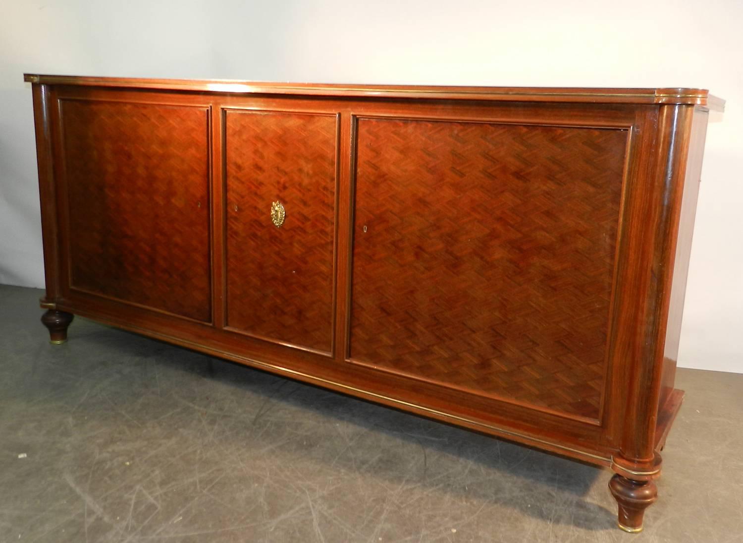 Jules Leleu. Veneer walnut sideboard with three diamond marquetry design doors. Central bronze ornament; signed.