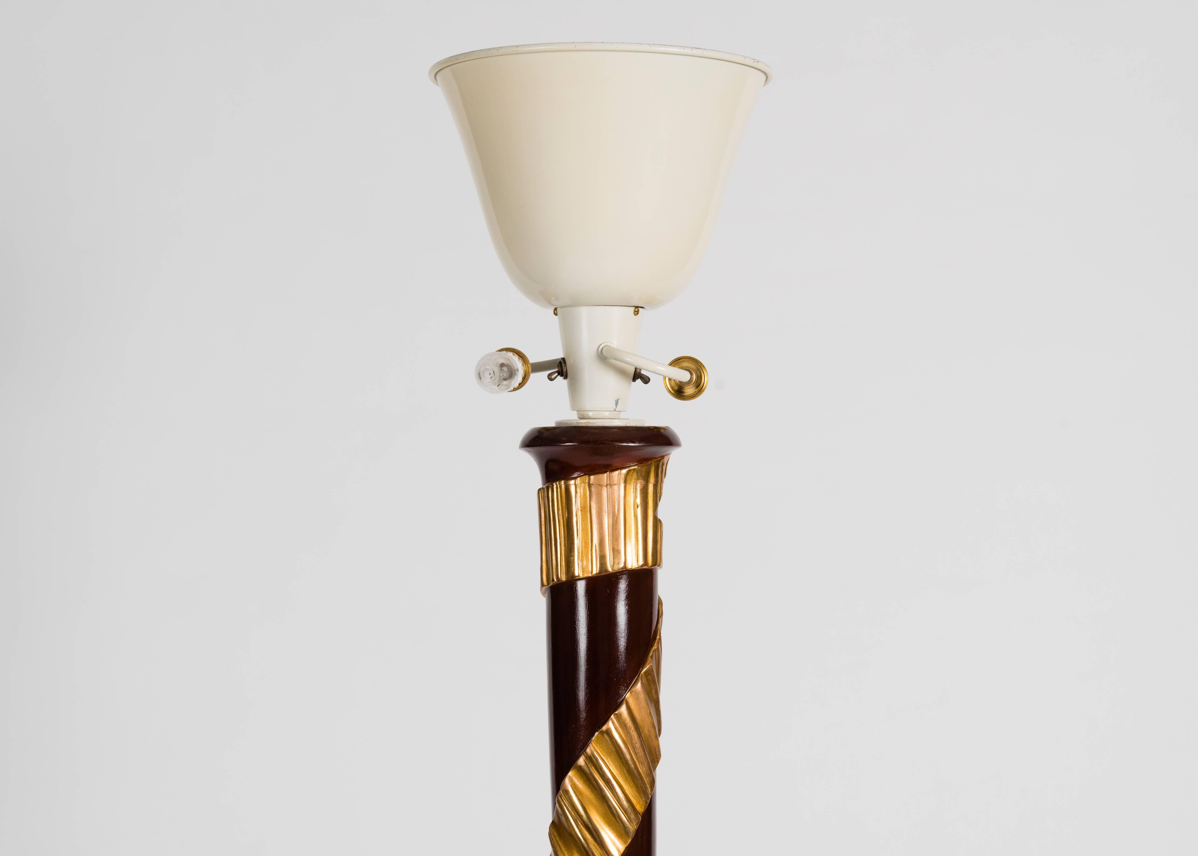 Numbered: 20939

A luxuriant floor lamp with a tapered body that terminates in a disk-shaped base at its bottom. Around the central column of the lamp wraps a ribbon motif, achieved by gilt detailing.