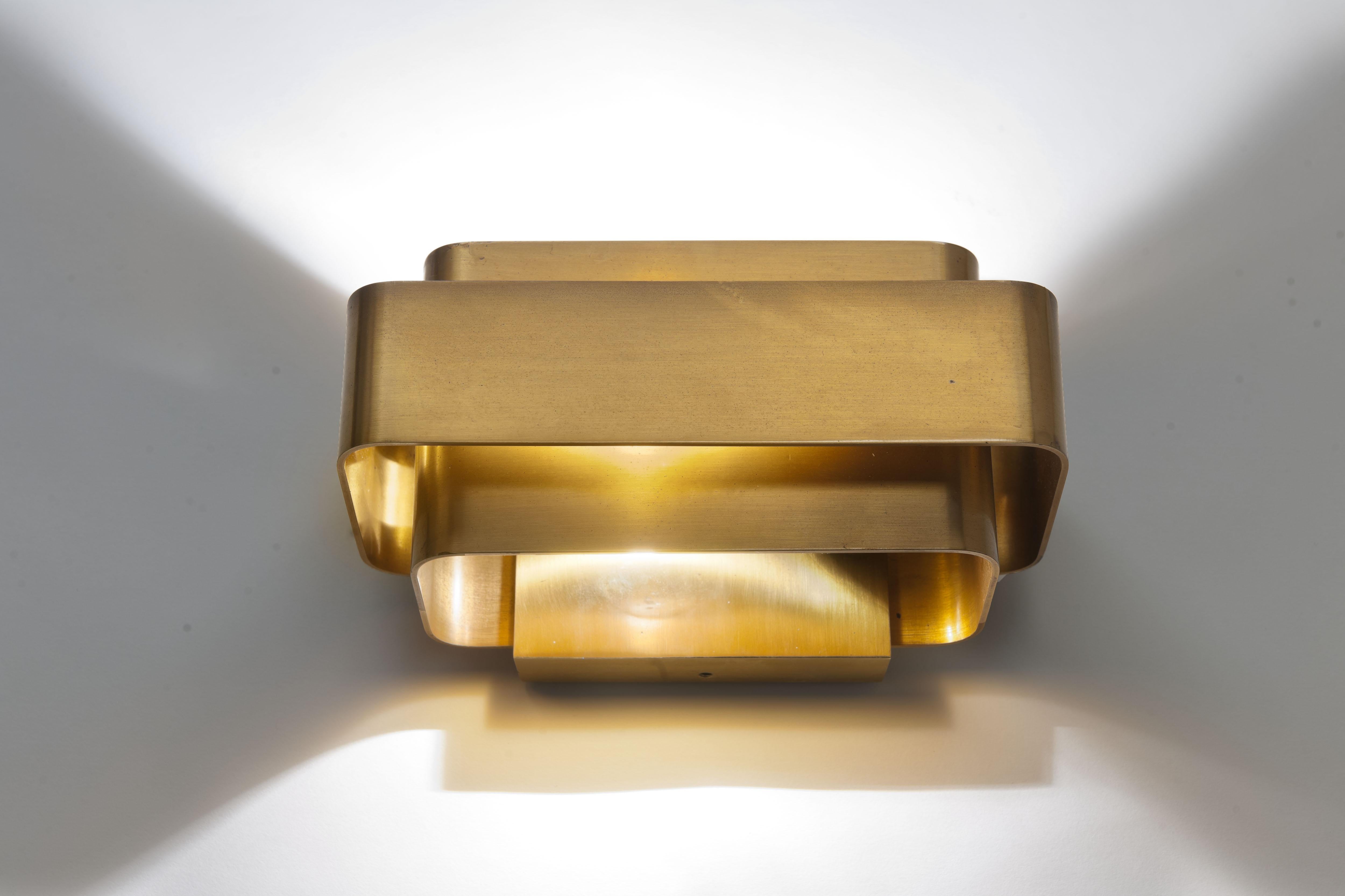 The small wall lamp by Jules Wabbes was designed in 1968 and is composed of three flat bent brass plates from which a gentle light shines.
The lamp is a rare little jewel of exceptionally quality (2 kg). 

The original patina is beautiful and