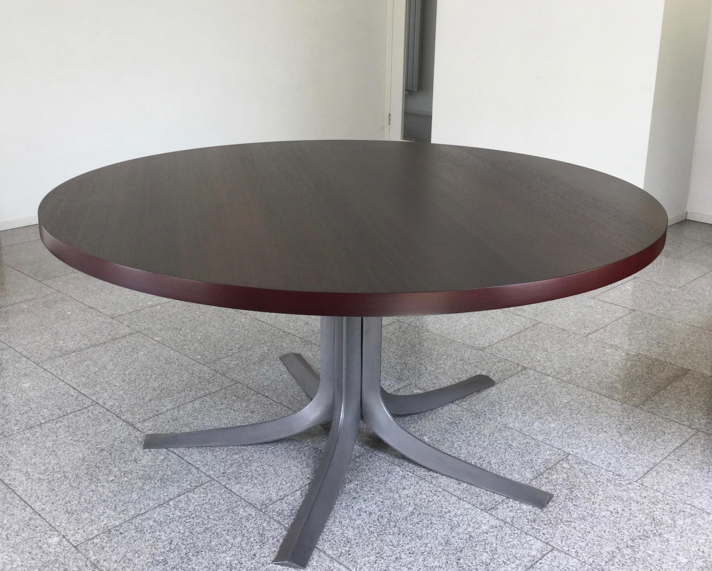 Pan Coupé table is one of the most fundamental creations of Jules Wabbes, a Belgian design icon in the 1950s thru the 1970s. The thick tabletop of veneered smoked oak is supported by the organic and graceful base of anodized cast aluminum. The