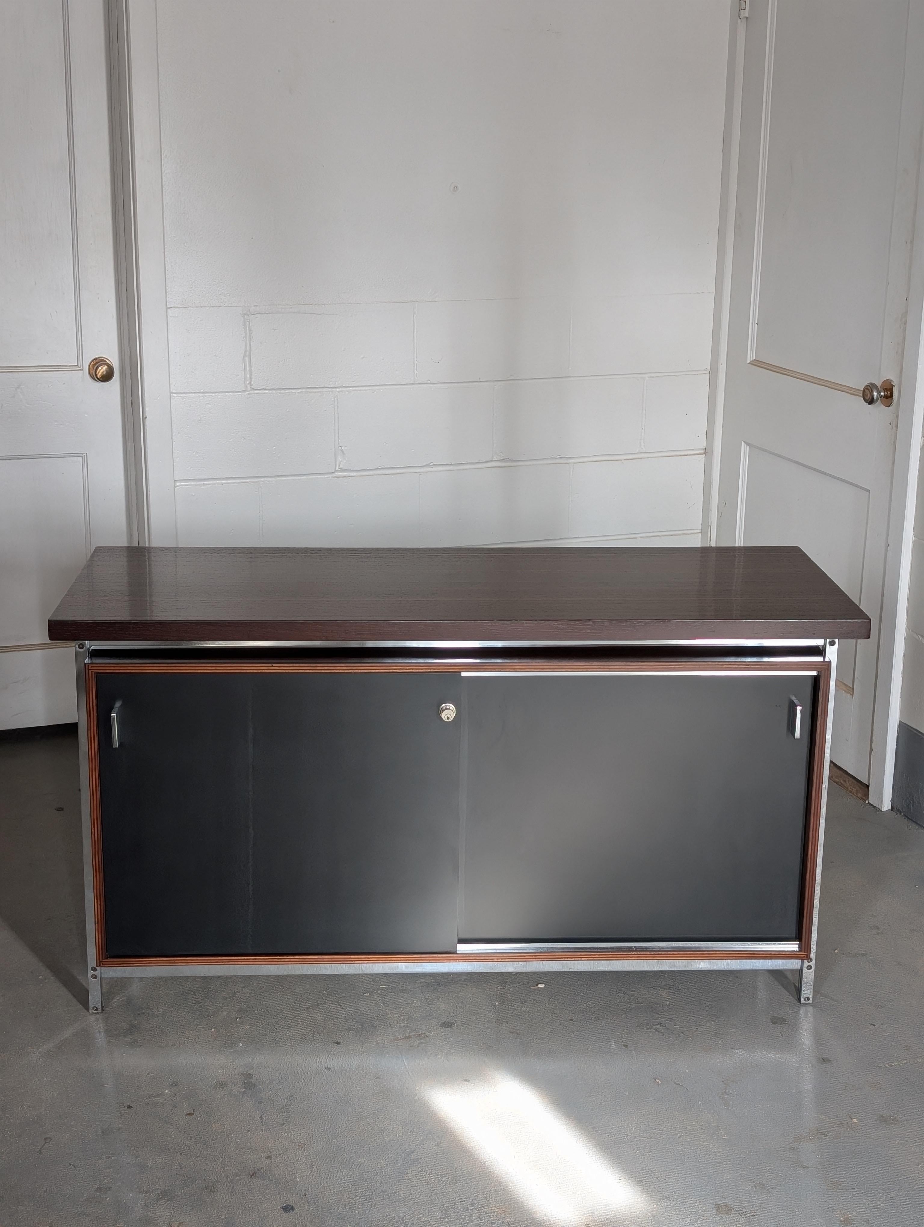 Credenza or sideboard designed by Jules Wabbes for Le Mobilier Universel, Belgium, circa 1960s.

Floating solid wenge top, chrome plated cabinet frame and handles. Two black lacquered sliding doors open to separate compartments, one adjustable