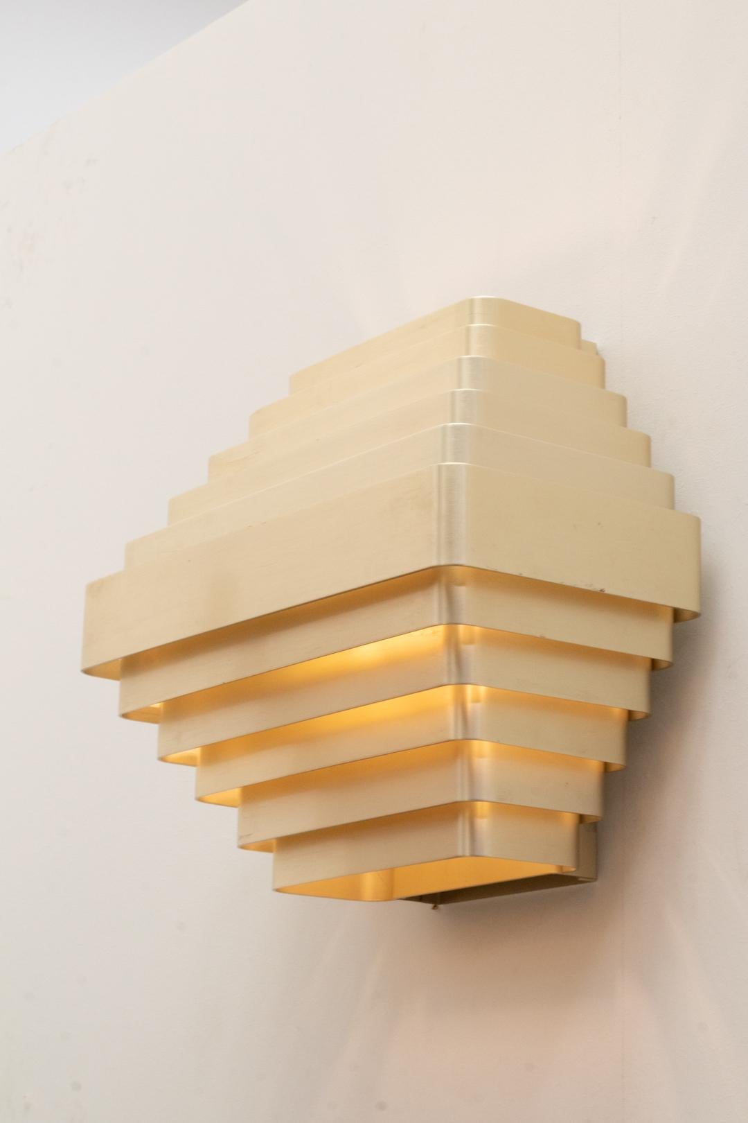 Large wall lamp by the belgian designer Jules Wabbes, dating back to circa 1970.
 It features 11 aluminum with a gold-finished strips  ... a great light effect and  a warm illumination.
This wall lamp is an original vintage piece, all in remarkably