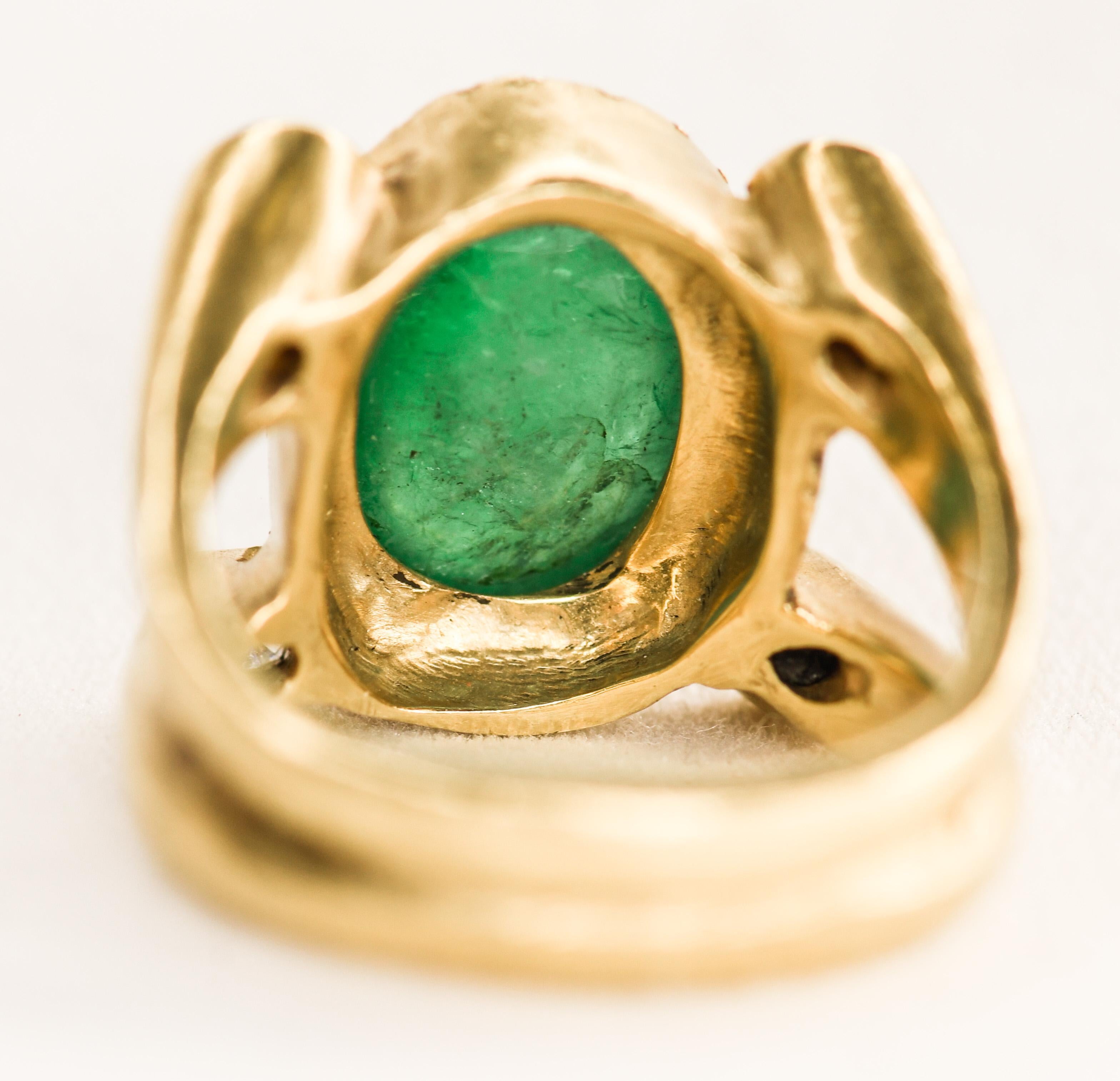 This handcrafted 18K yellow gold ring features an oval 6 carat cabochon Colombian emerald enhanced with approximately 40 points of round white diamonds.  Appropriately hallmarked and signed 