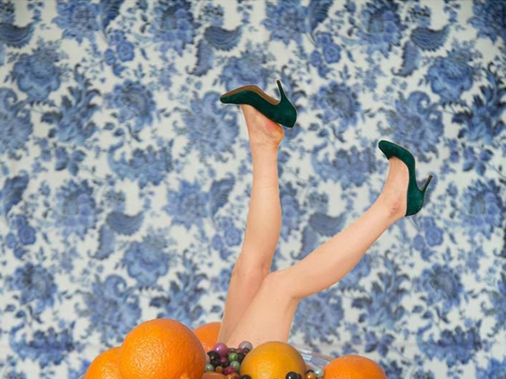 Marge - Still life with oranges, a woman's legs, & floral wallpaper - Photograph by Julia McLaurin