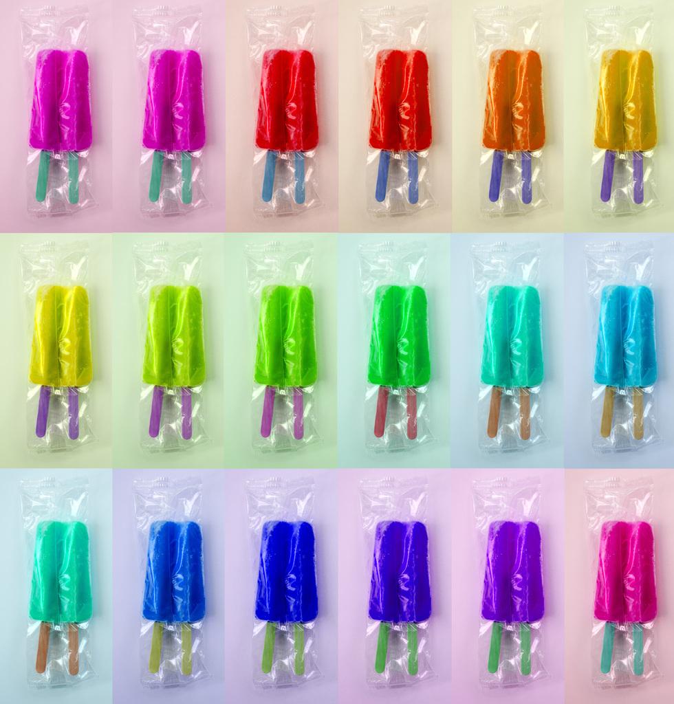 Julia McLaurin Still-Life Photograph - Rainbow Pop - Grid of colorful rainbow summer ice double popsicles in wrappers