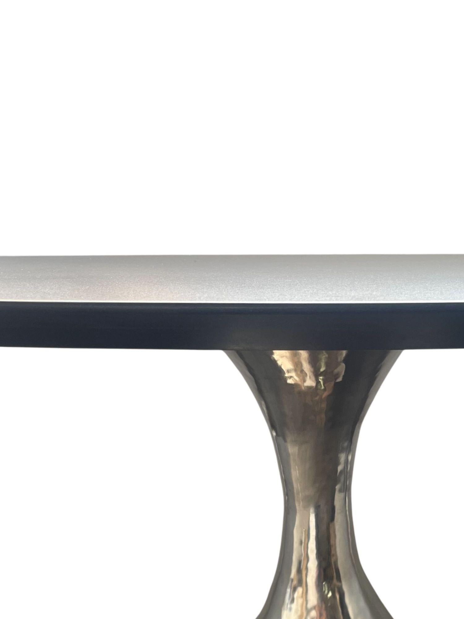 A substantial and elegant Dakota oval table by Julian Chichester, blending modern craftsmanship with timeless materials. The table features a beautifully honed marble top resting on a sturdy metal base with a sleek, contemporary design. The