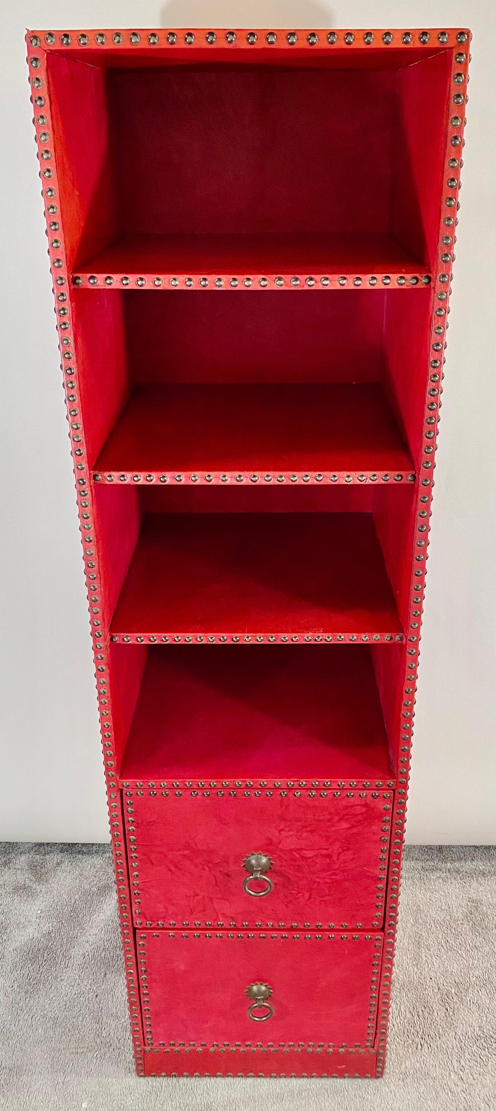 An exquisite pair of red leather tooled bookcases or cabinets designed by the New York artist and furniture designer Julian Schnabel ( American, 1951 ) exclusively for the historical Garmercy Park hotel in New York City. The bookcases feature three