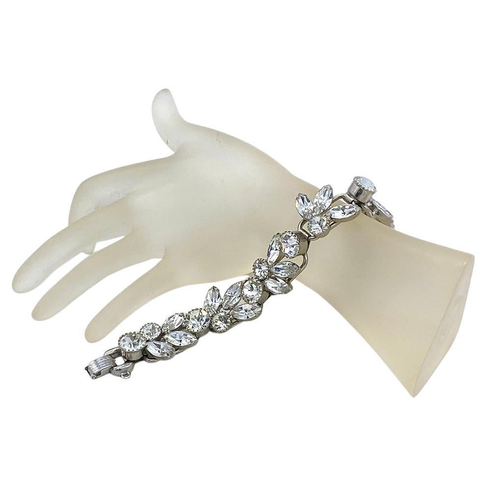 Il s'agit d'un bracelet identifié de Juliana D&E en strass clair. Les cinq segments de la grappe de pierres Chaton et Navette sont sertis sur des anneaux plaqués rhodium (5 anneaux sont la construction typique d'un bracelet) avec une chaîne de