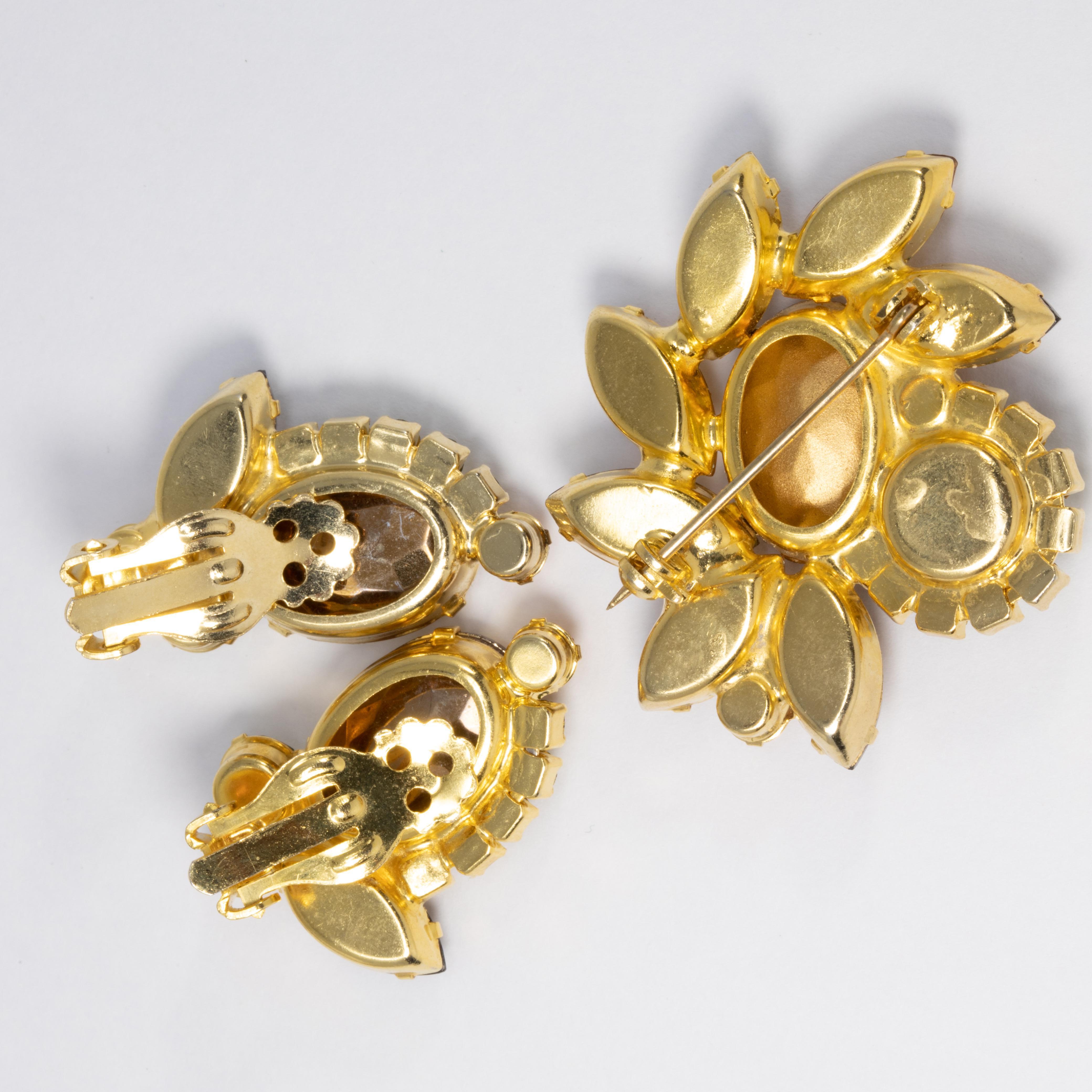 An exquisite brooch/pin and a pair of clip-on earrings by Juliana DeLizza & Elster. A single watermelon crystal is prong set and accented with smaller chatons and navettes in amber, green, yellow, and orange colors.

Pin: 4.3cm x 3.9cm
Earrings: