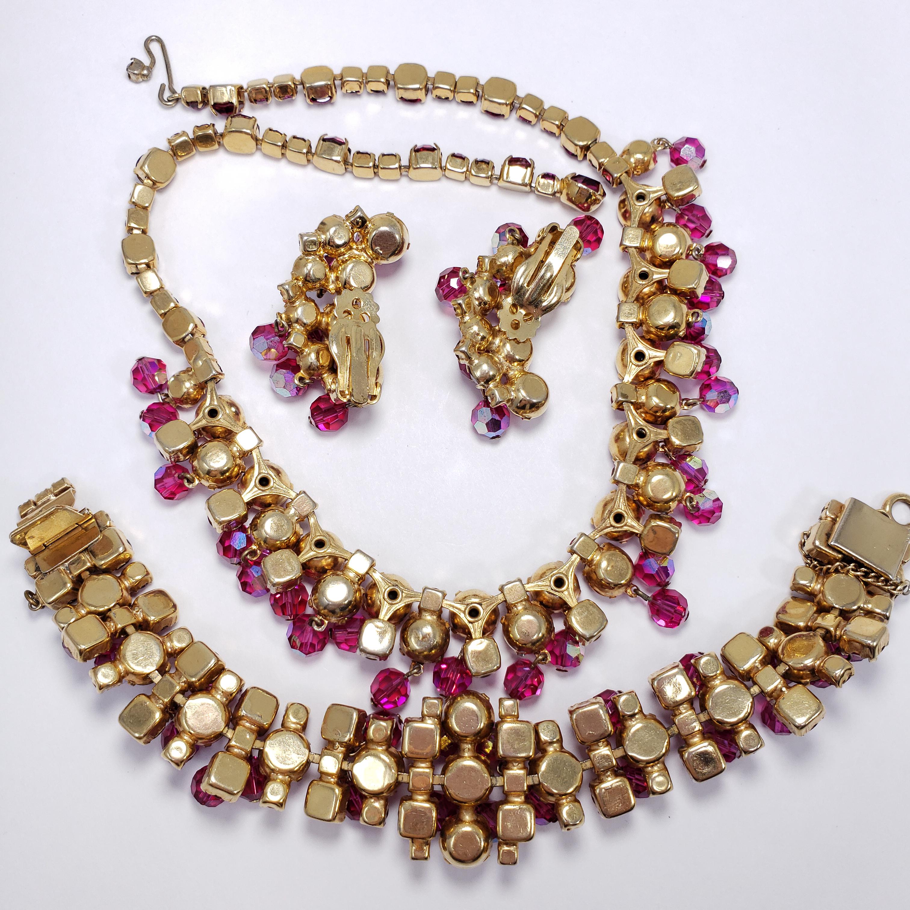 Enticing, vibrant fuchsia rhinestones are the foundation for this amazing display of aurora borealis faceted dangles layered throughout this fabulous necklace, link bracelet, and cluster clip earrings parure. From the Juliana line by DeLizza and