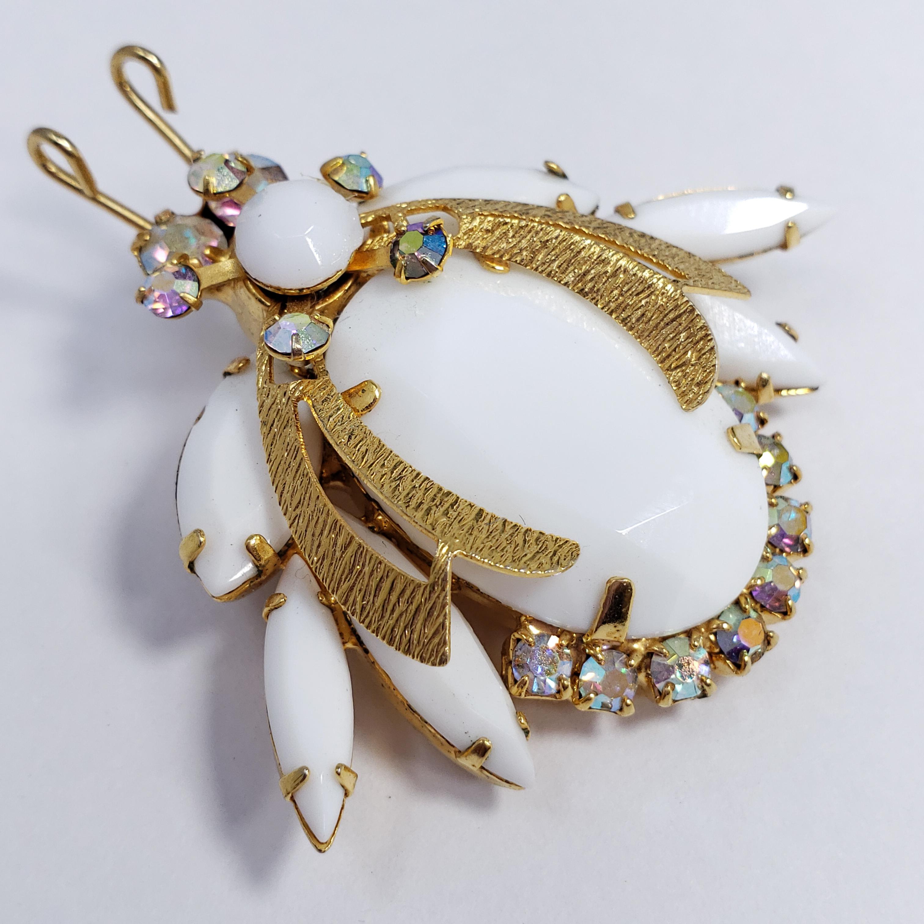 A dazzling pin from the DeLizza and Elster Juliana collection! An opaque white glass crystal beetle is accented with glittering aurora borealis crystals, set in gold tone. 

