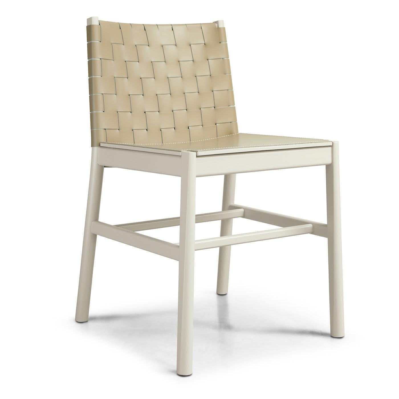 Con un exquisito entrelazado en el respaldo, esta refinada silla recuerda al diseño arquetípico. La estructura de madera de haya con patas ligeramente inclinadas unidas por una barra horizontal sostiene un asiento de madera recubierto de fina piel,