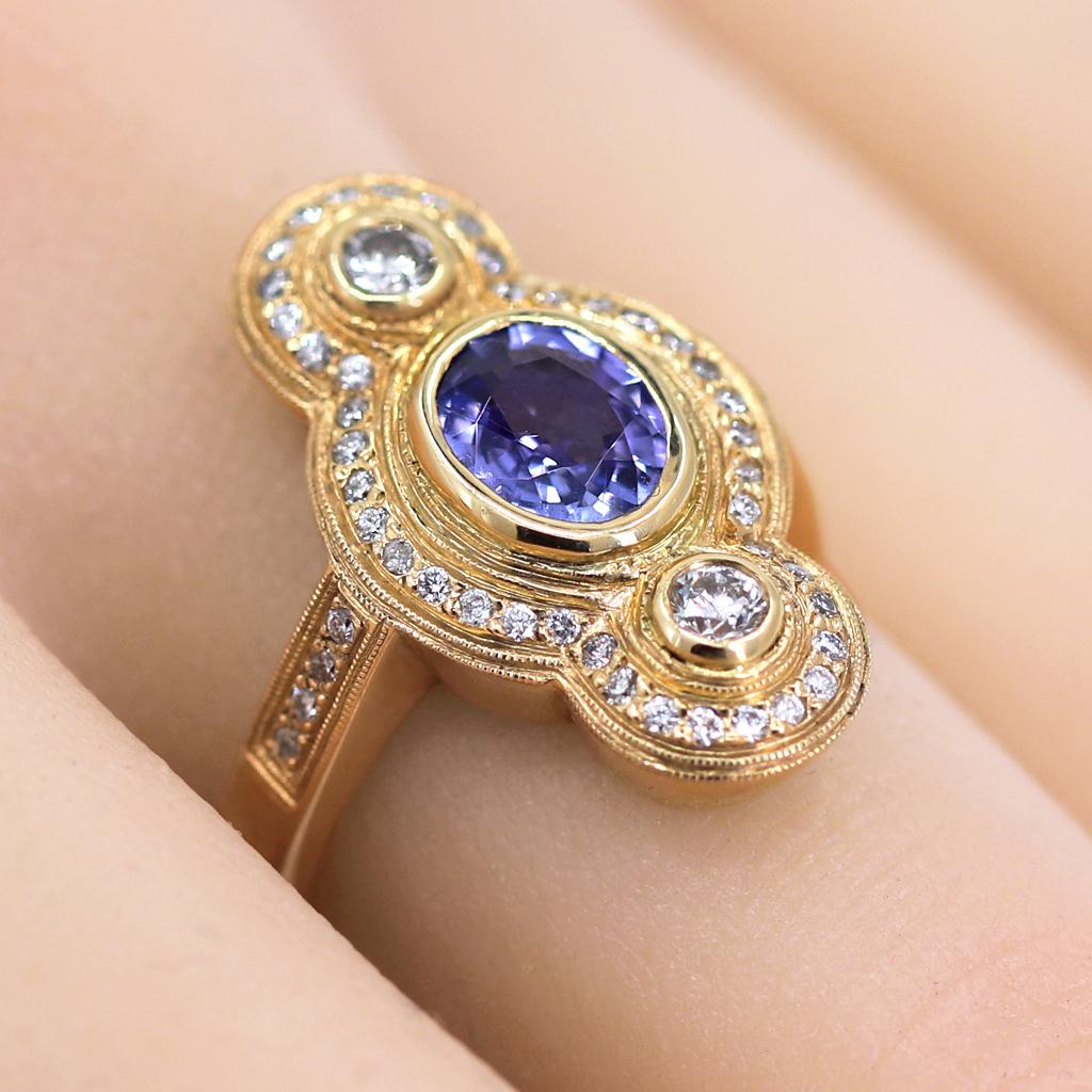 One of a Kind Ring by jewelry designer Julie Romanenko of Just Jules, intricately hand-fabricated in 14k yellow gold featuring a gorgeous faceted tanzanite oval bezel-set and accented with round brilliant-but white diamonds totaling 0.54 carats.