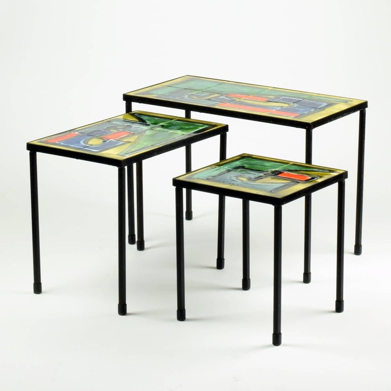 Juliette Belarti, Belgium
Nesting tables (set of 3), 1960s.

Hand painted and glazed tile top on black iron base.

Excellent condition with no damage to the tile tops. Some age-related wear to the iron bases.