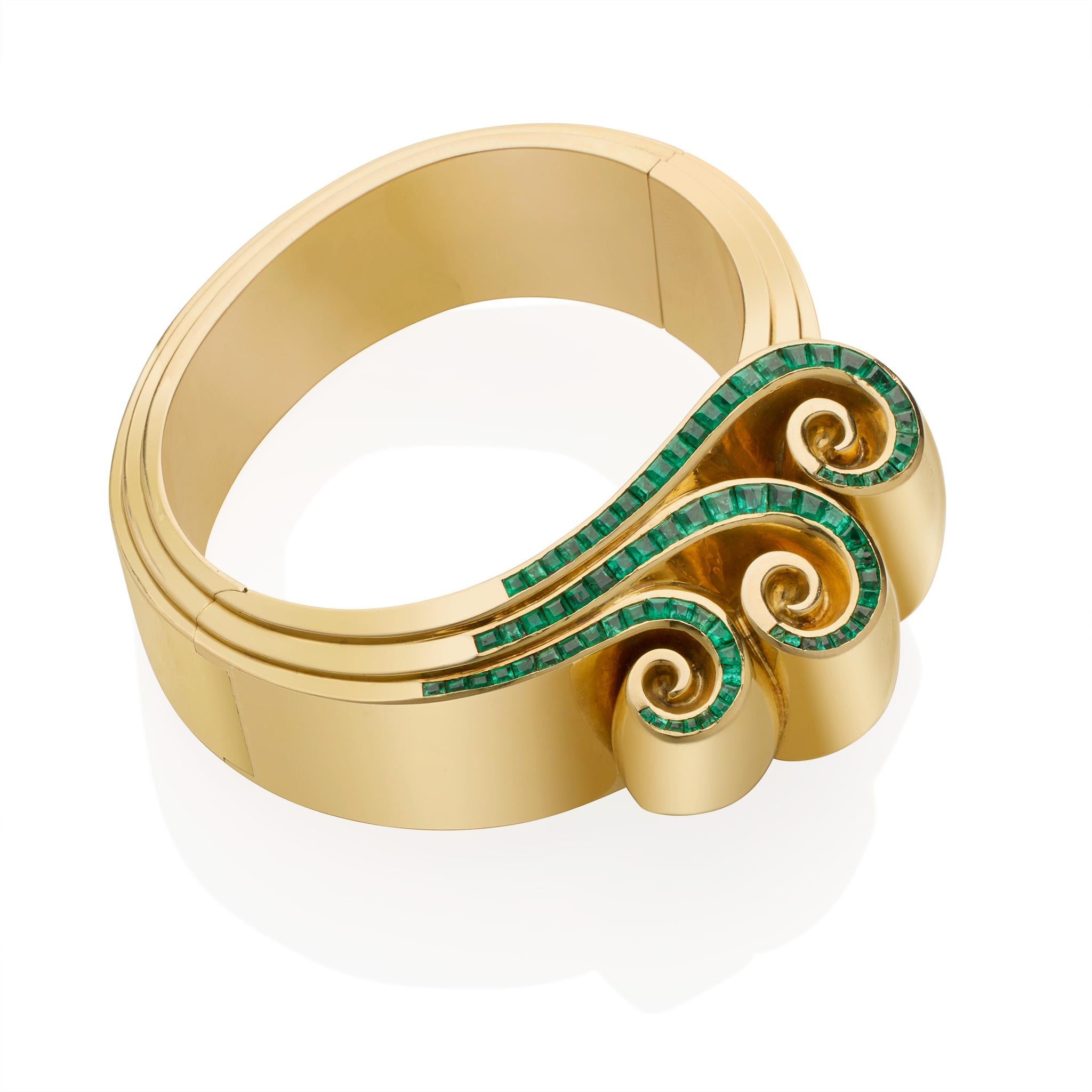Dating from June 1938, designed by Juliette Moutard of René Boivin Paris, and created by the workshop of Henri Heugas, these Retro 18K gold and emerald jewels date from the 1930s. The wide bangle with stepped edges is surmounted by three bold ribbon