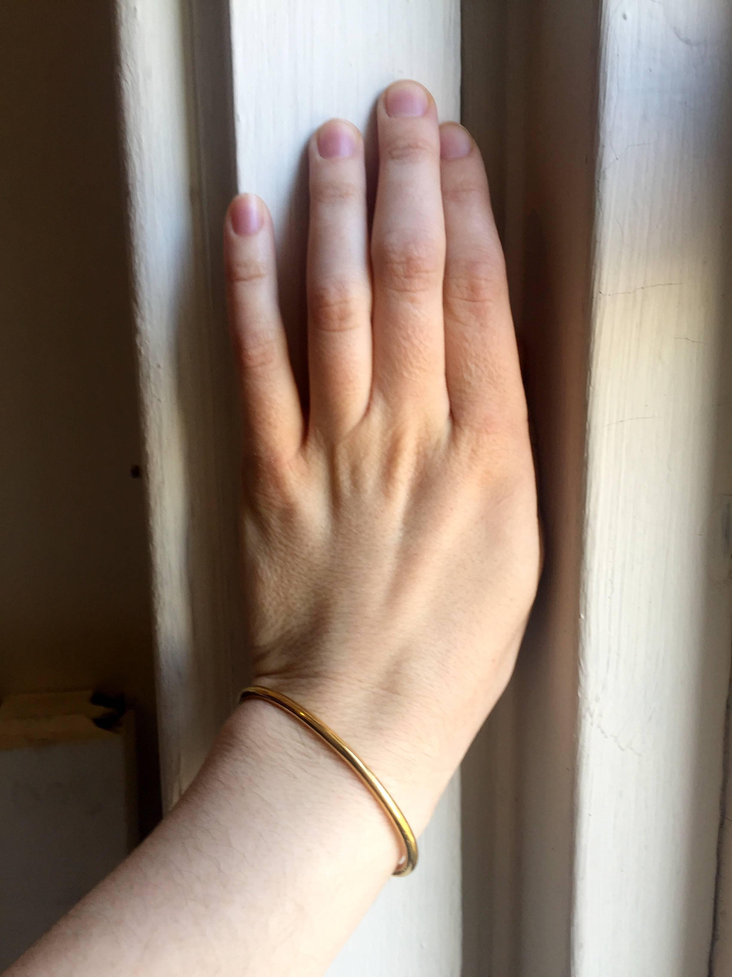 This solid 24 Kt Gold bangle is a staff favorite and a great everyday bracelet.  Lustrous and malleable yellow gold forms to the wrist and develops a warm patina with wear.  

Can also be engraved upon request.  Please allow an extra week for