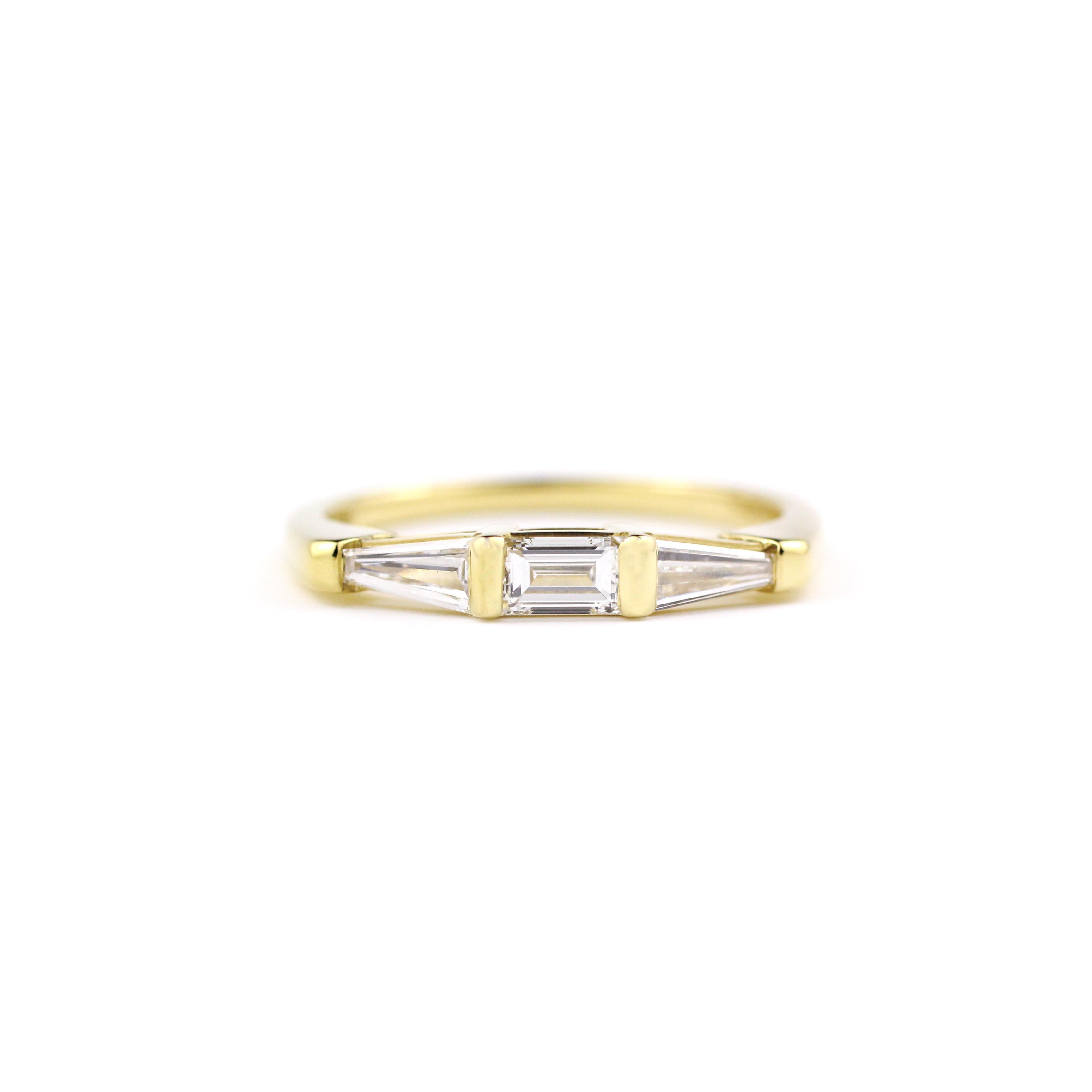 Dieser moderne und elegante Ring aus 18-karätigem Gold enthält einen Baguette-Diamanten (.23 ct.), der von zwei spitz zulaufenden Baguette-Diamanten (.28 ct.) flankiert wird.

Größe 6 1/2 auf Lager und sofort lieferbar.

Dieser Ring kann in der