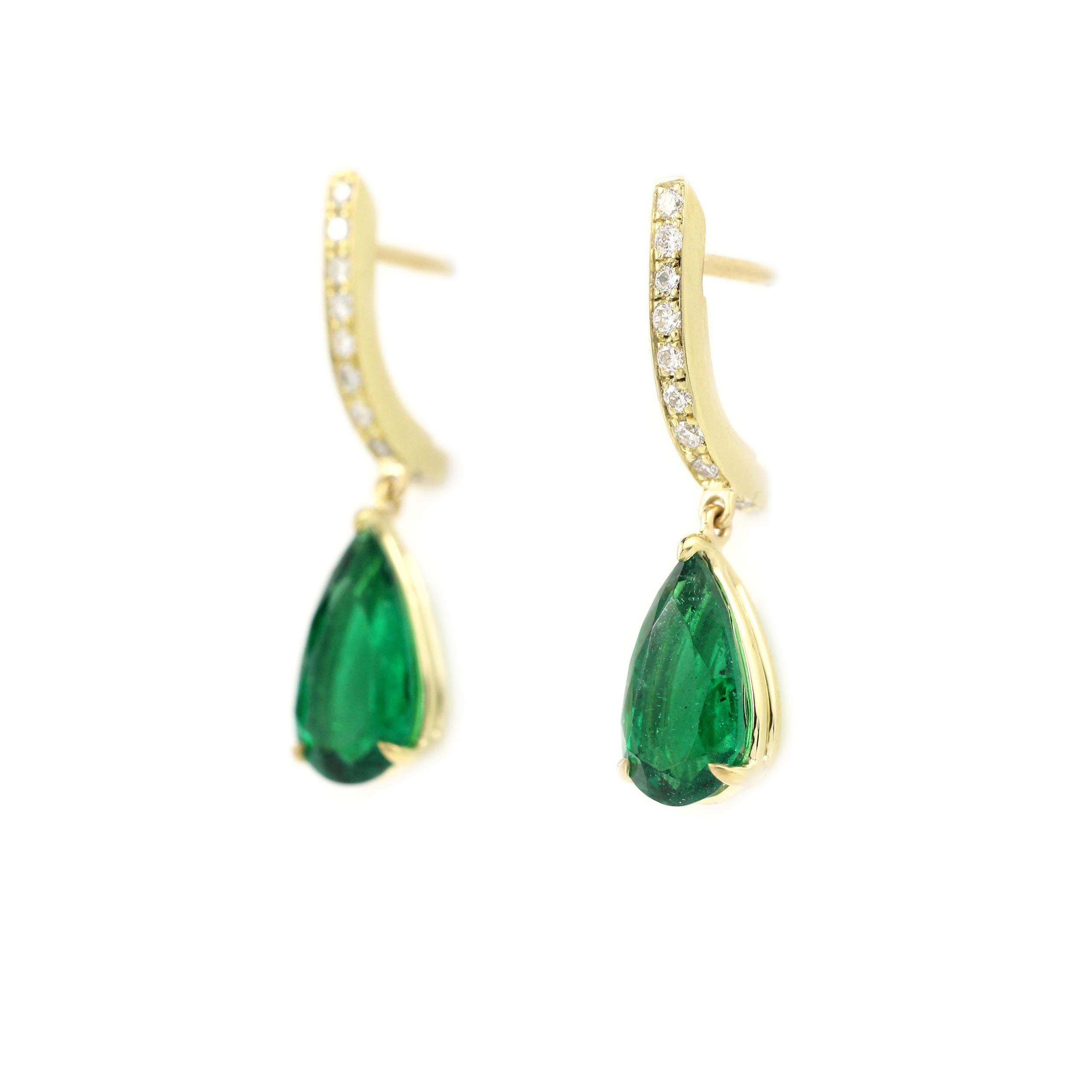 This fine pair contains two GIA Certified Pear-Shape Natural Emeralds at 1.20 Cts. and 1.11 Cts. A well-matched pair of beautiful Zambian stones of deep green color.    18 Kt Yellow Gold and Diamond pave tops with post-backs.  

This is an