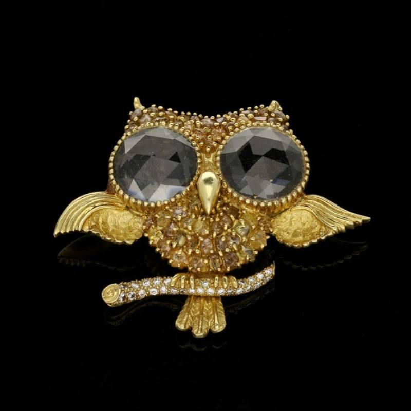 A charming wise owl brooch by Julius Cohen circa 1960s, the body set throughout with yellow and brown rough diamond crystals, the wings and tail with textured finish and the eyes both set with a large rose-cut rock crystal quartz, all in finely