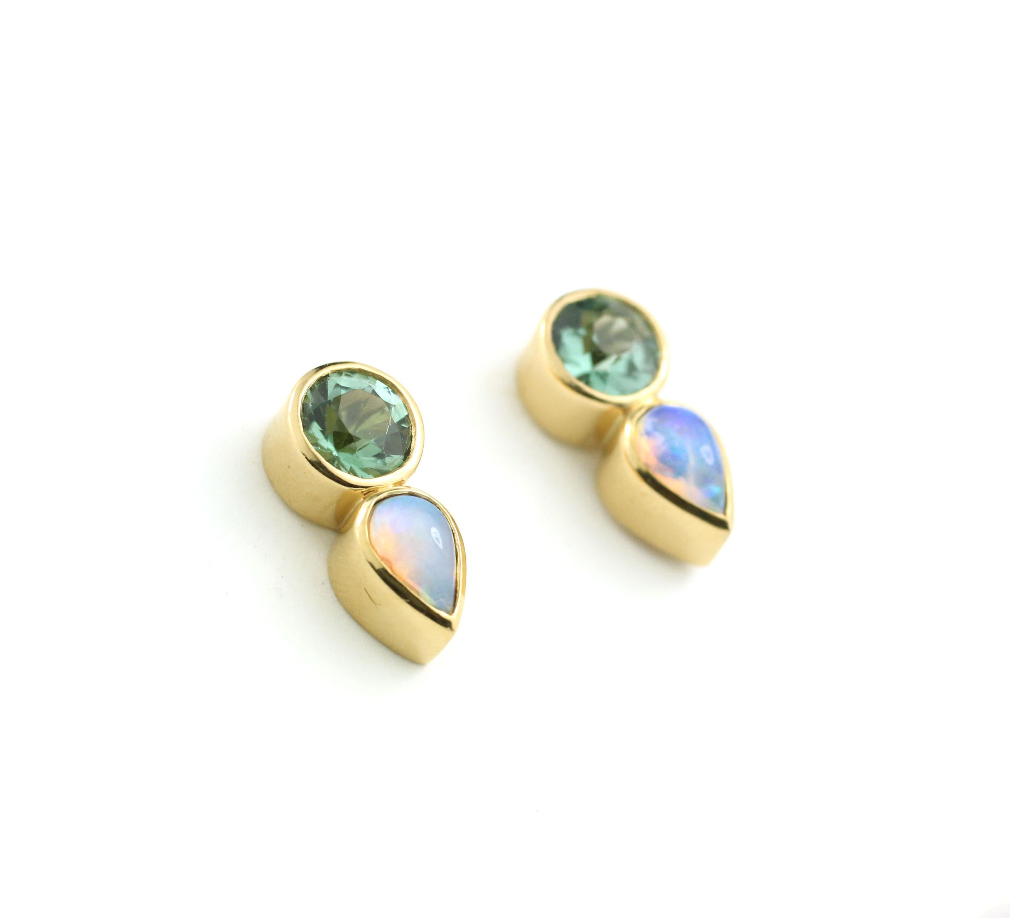 These stud earrings are made special by the unique pairing of two round, faceted, mint green Tourmalines of exceptional brightness (1.01 Cts.) with two fiery, pear shape Opals (.46 Cts.).  Bezel set in 22Kt Gold with 18 Kt Gold posts and backs, for