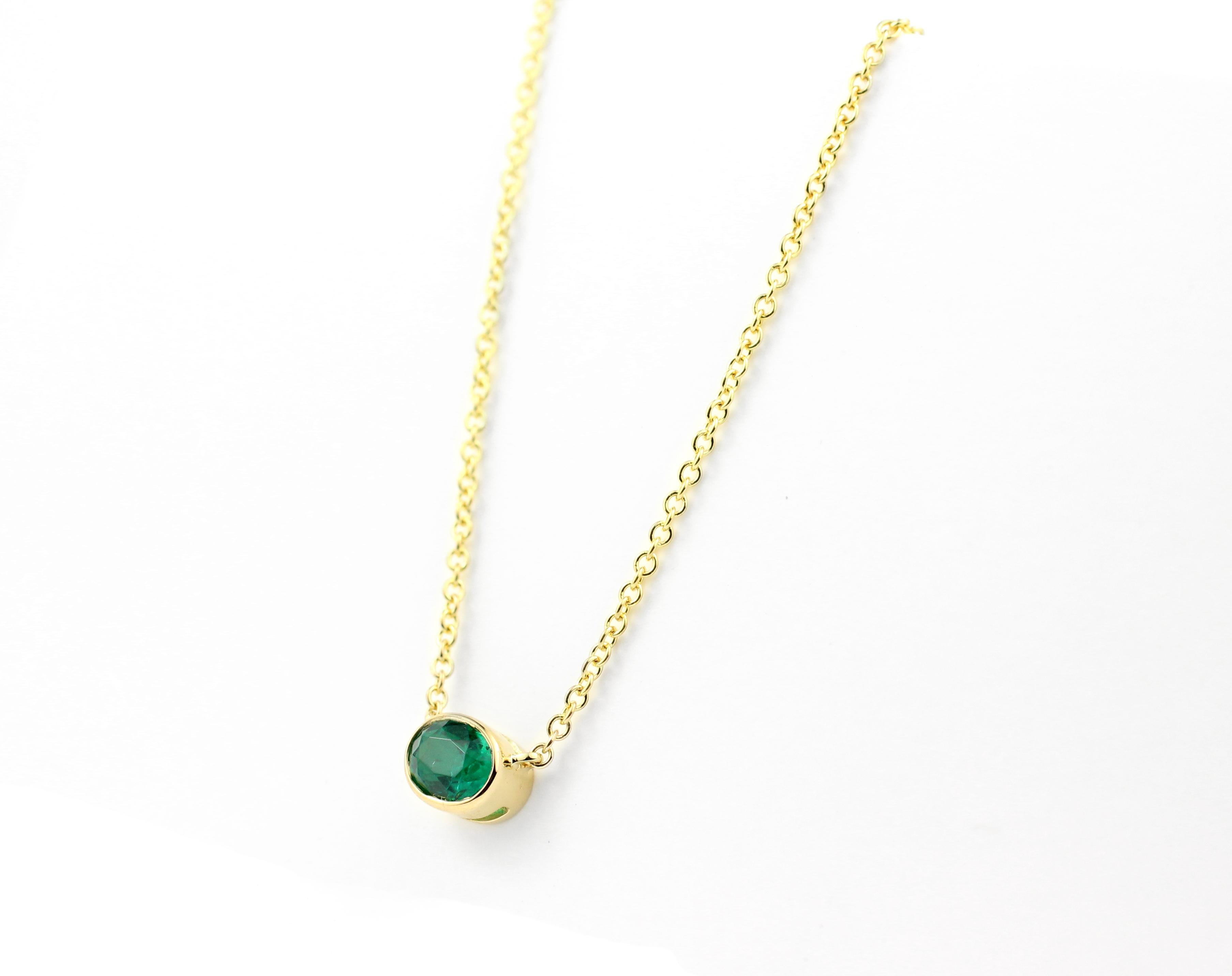 This necklace features one beautiful .45 Ct. Oval Emerald set in an 18 Kt Gold bezel on a delicate 1.3 mm 18 Kt Gold Chain.

Necklace is 16” Long.

This necklace style is available made-to-order in all birthstones.  Price varies with stone choice. 