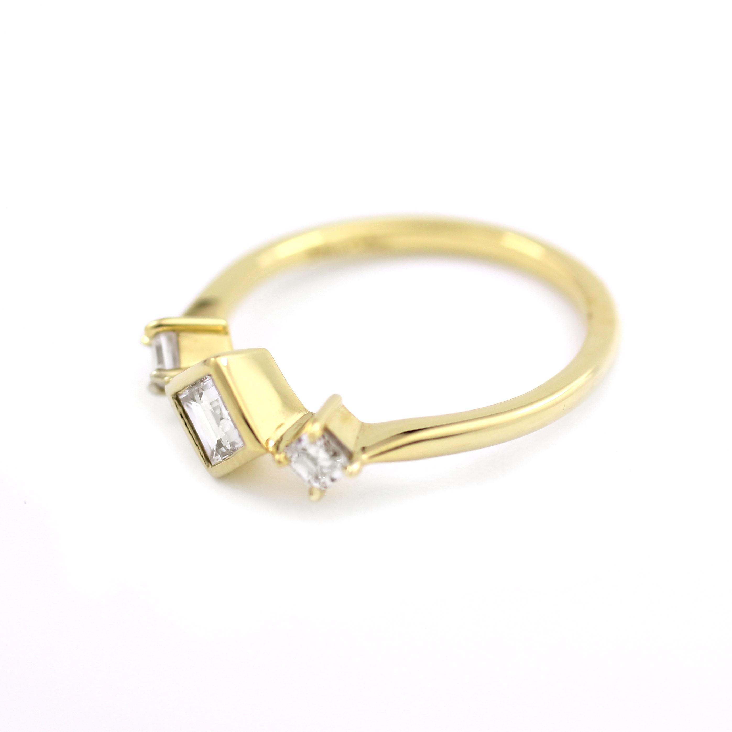 This unique, 18 Kt Gold ring contains one Square-cut Diamond (.30 Cts.) bezel set on the diagonal and flanked by two prong-set Princess Cut Diamonds (.22 Cts.).  A one-of-a-kind ring in an appealing modern style setting.   

Size 6 1/2 for immediate