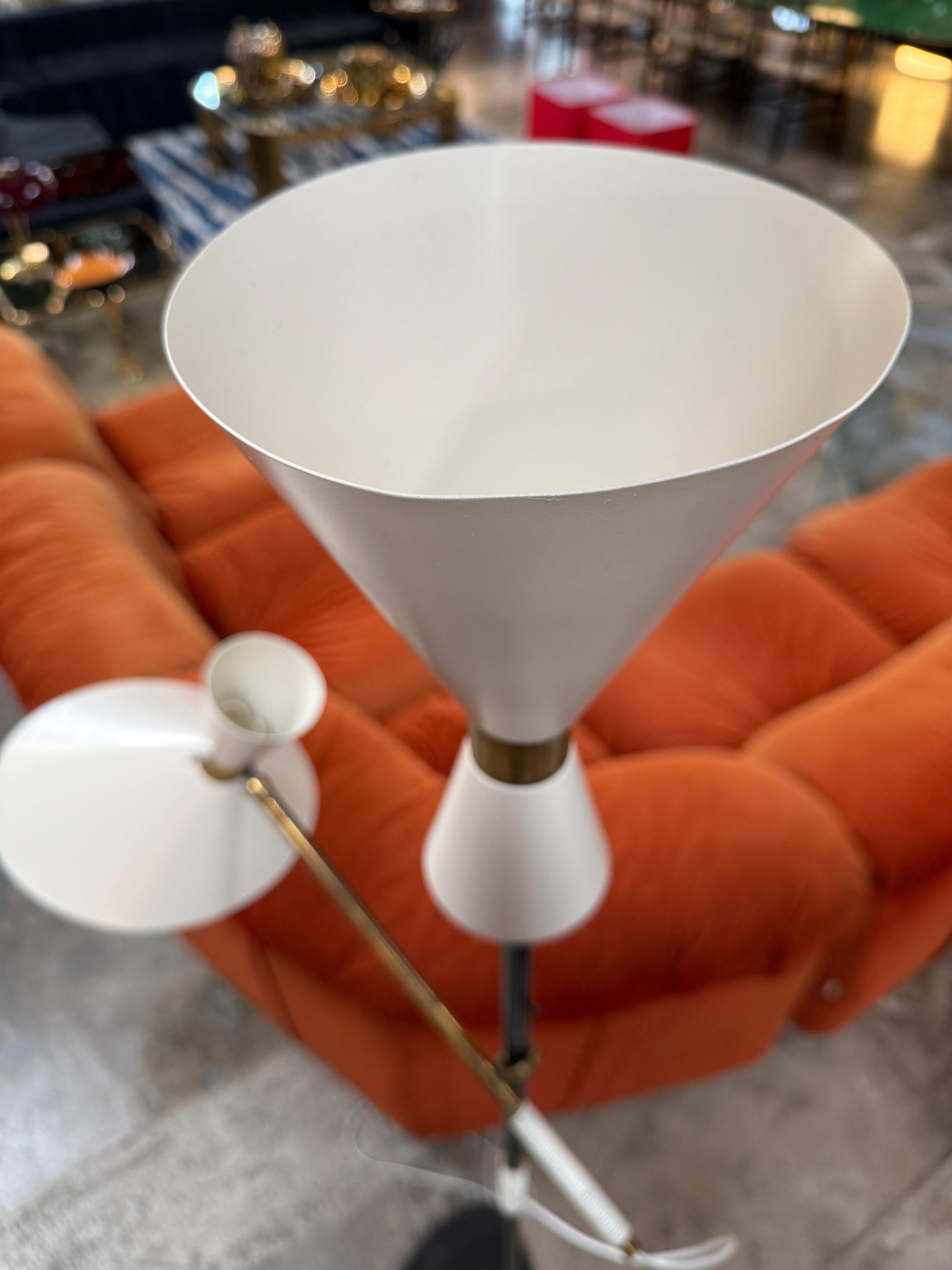 Ce rare lampadaire, connu sous le nom de modèle Pélican, a été conçu par Julius Theodore Kalmar en 1950. Whiting se caractérise par une tige sculpturale en métal noir, deux abat-jour coniques blanc crème et d'élégantes touches de laiton. Offrant à