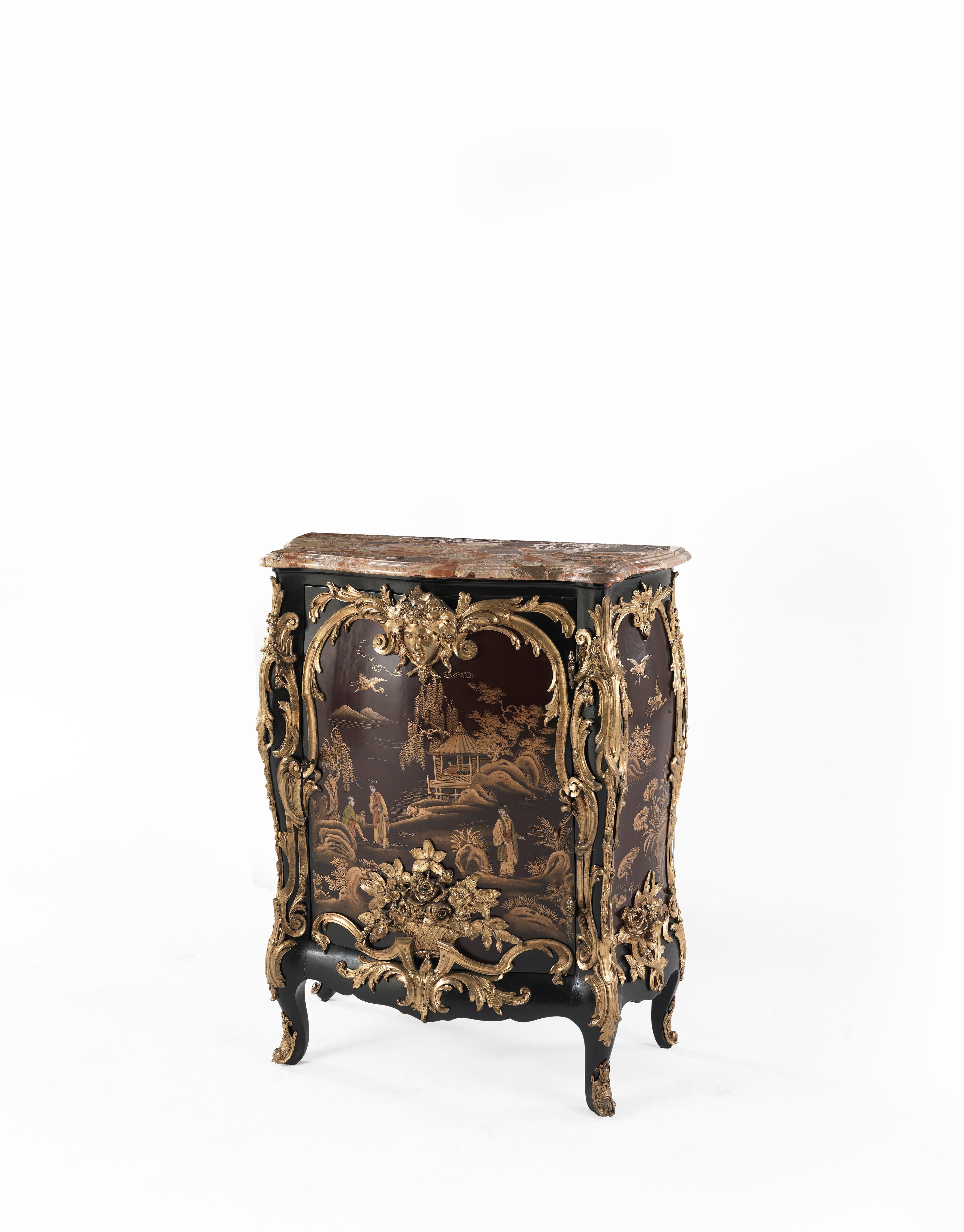 An important and richly decorated Italian ormolu-mounted and lacquered cabinet, ca. 1930.
The cabinet structural frame is in hardwood, darkened by painting. The bombé case has its surface lacquered, taking inspiration from Japanese subjects, with