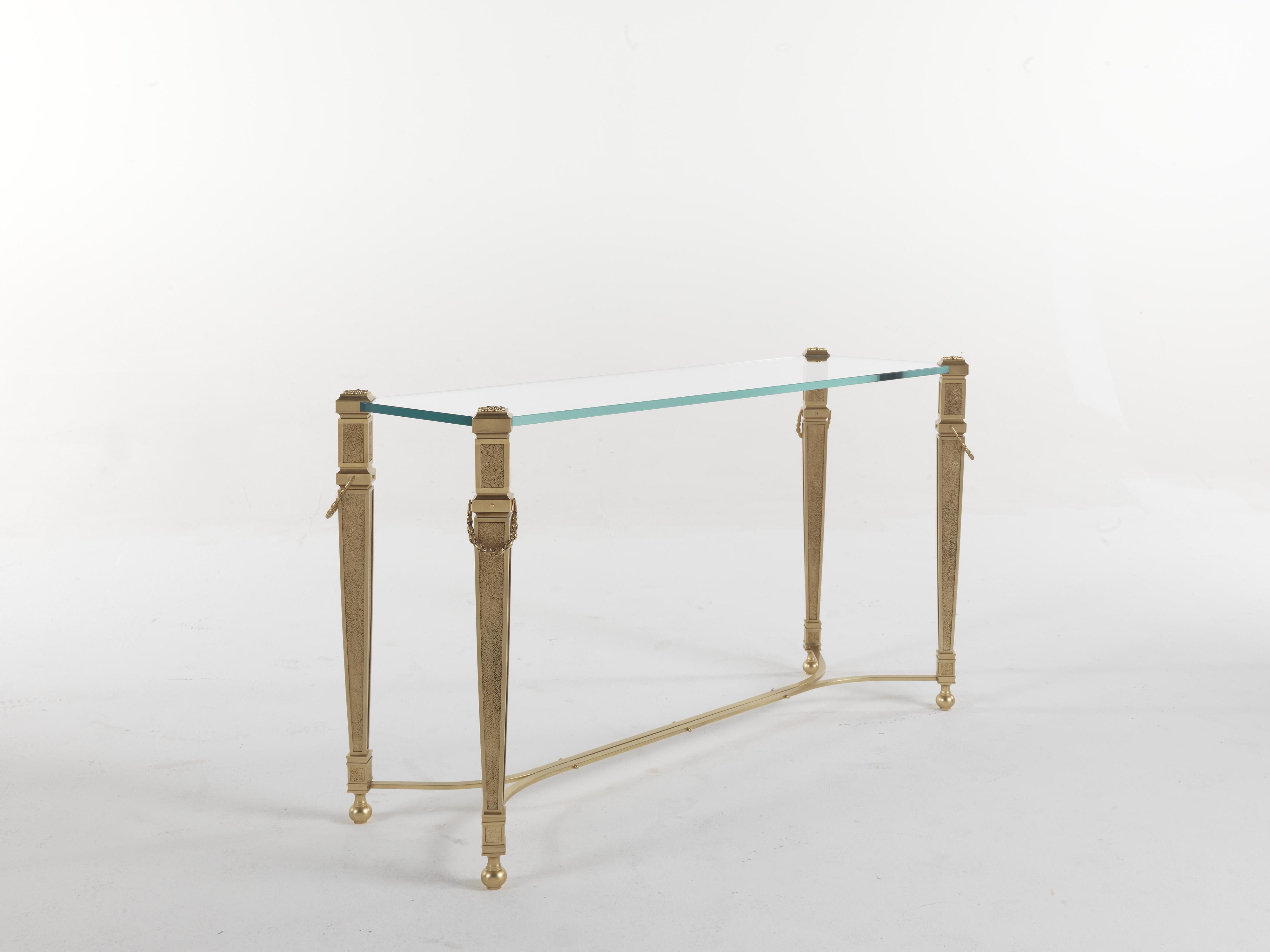 A light and refined design for Giove console. The structure, with a golden finish, features decorative elements in a neo-classical style, while the top is in extra light glass. A piece of furniture with a versatile and timeless style, able to fit