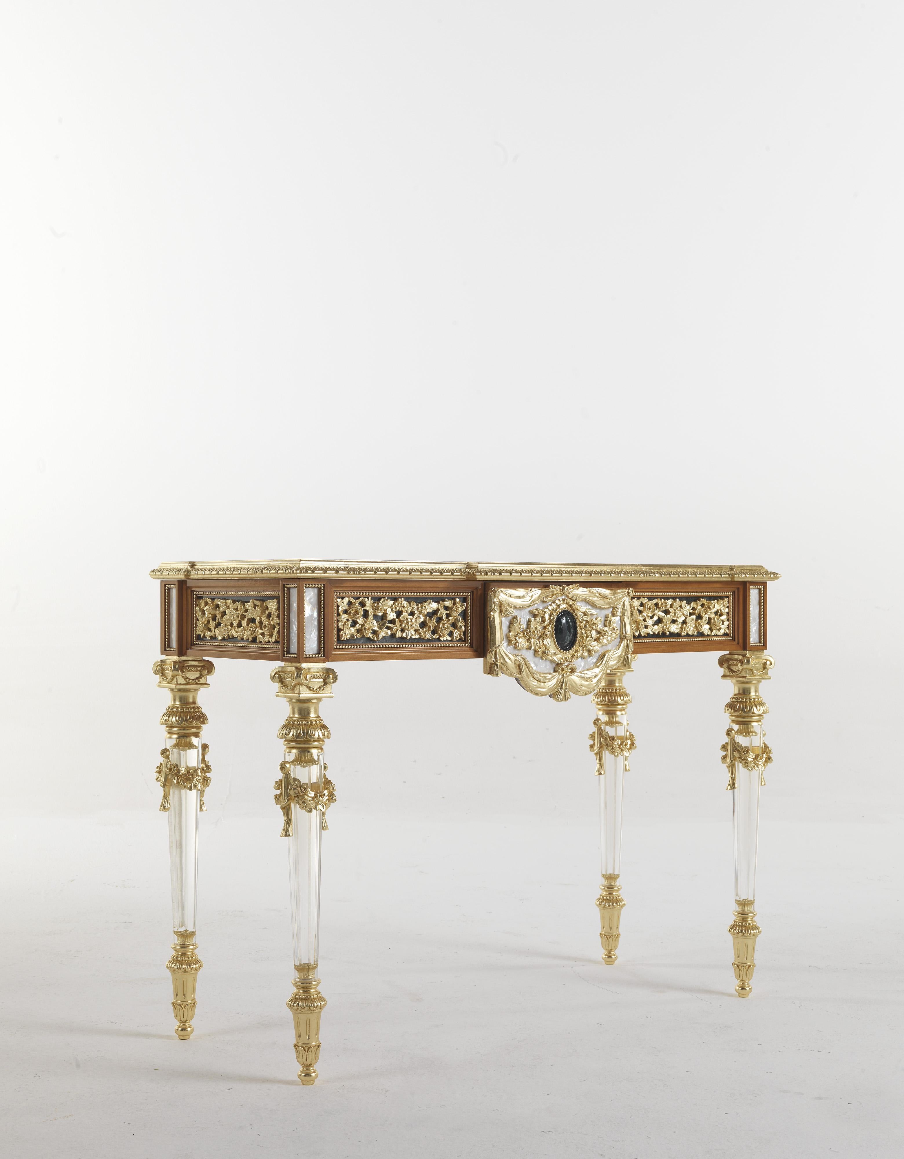 A splendid console in Louis XVI style, of fine Italian cabinetry. The structure with light walnut finish is characterized by hand-carved details finished in gold leaf and mother-of-pearl decorations, the legs are also hand-carved while the top has