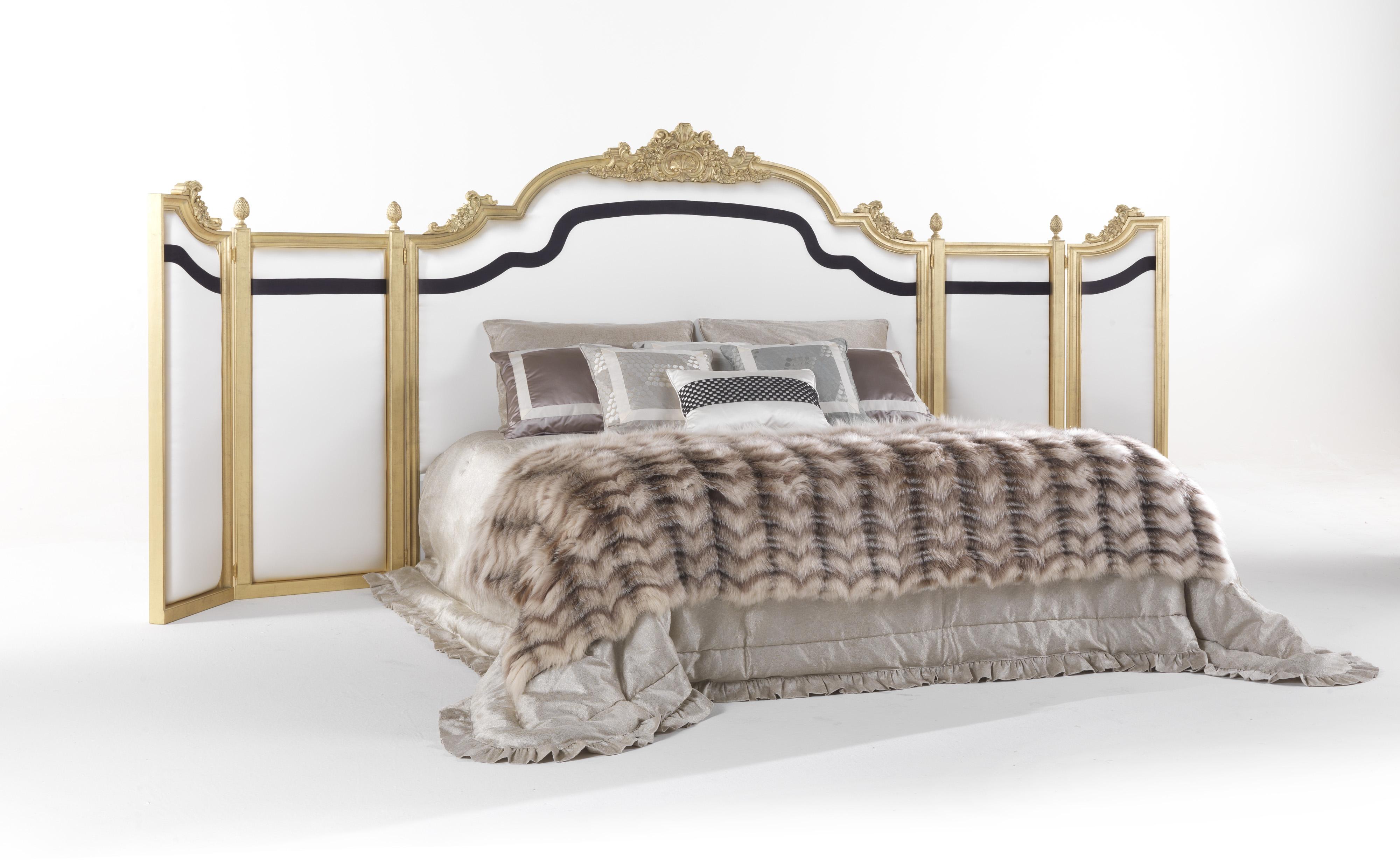 An impactful bed characterized by mobile panels embracing the night tables and the headboard. The refined game of lines created by the contrasting black strip adds movement to the movable panels, embellished by hand-carved wood decorations with