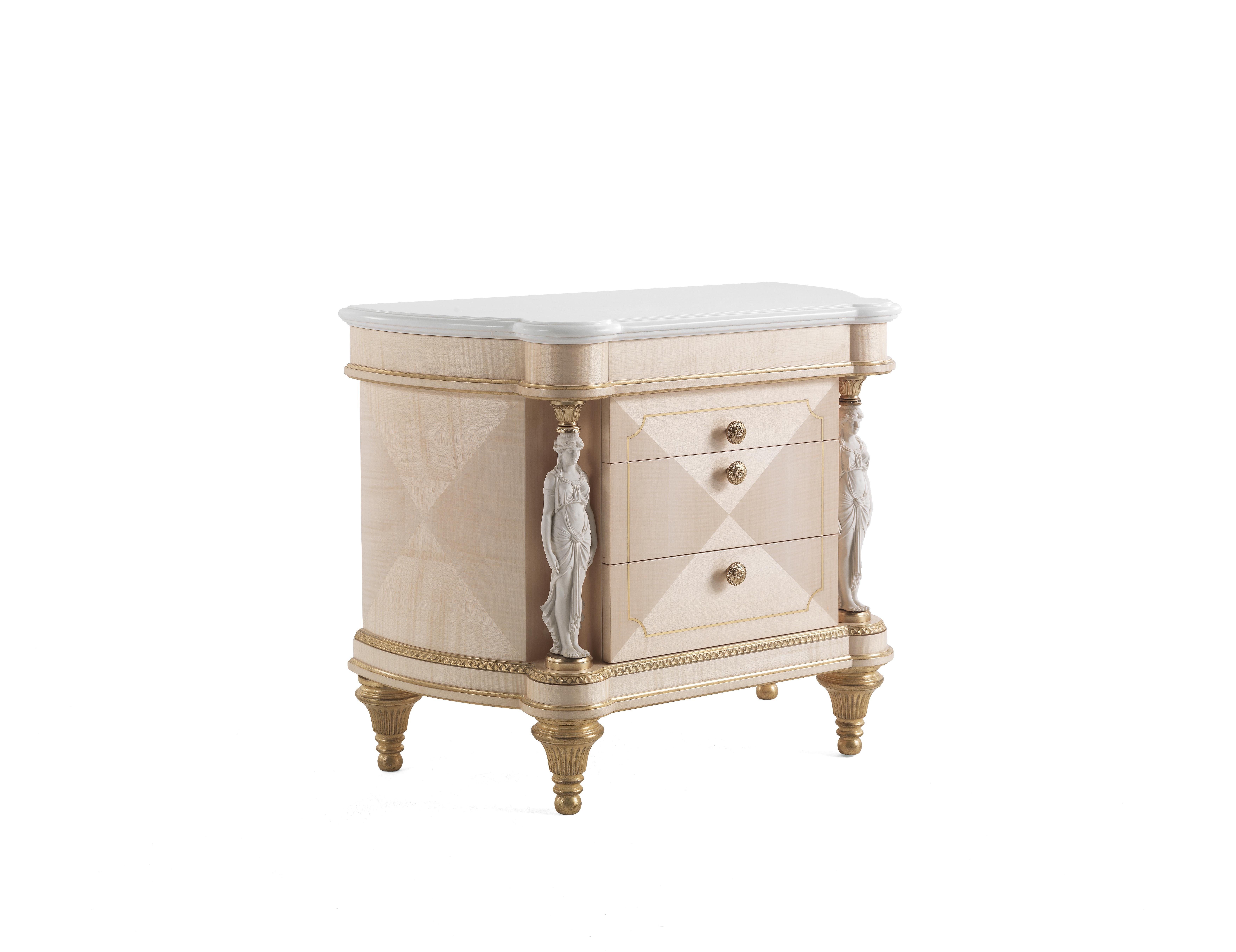 Toulouse night table with structure in multilayer maple. Three drawers. Profile and details are finished in antique gold with patina JG294. Decorative elements in metal are finished in gold. Statues with biscuit finishing as columns. Top in