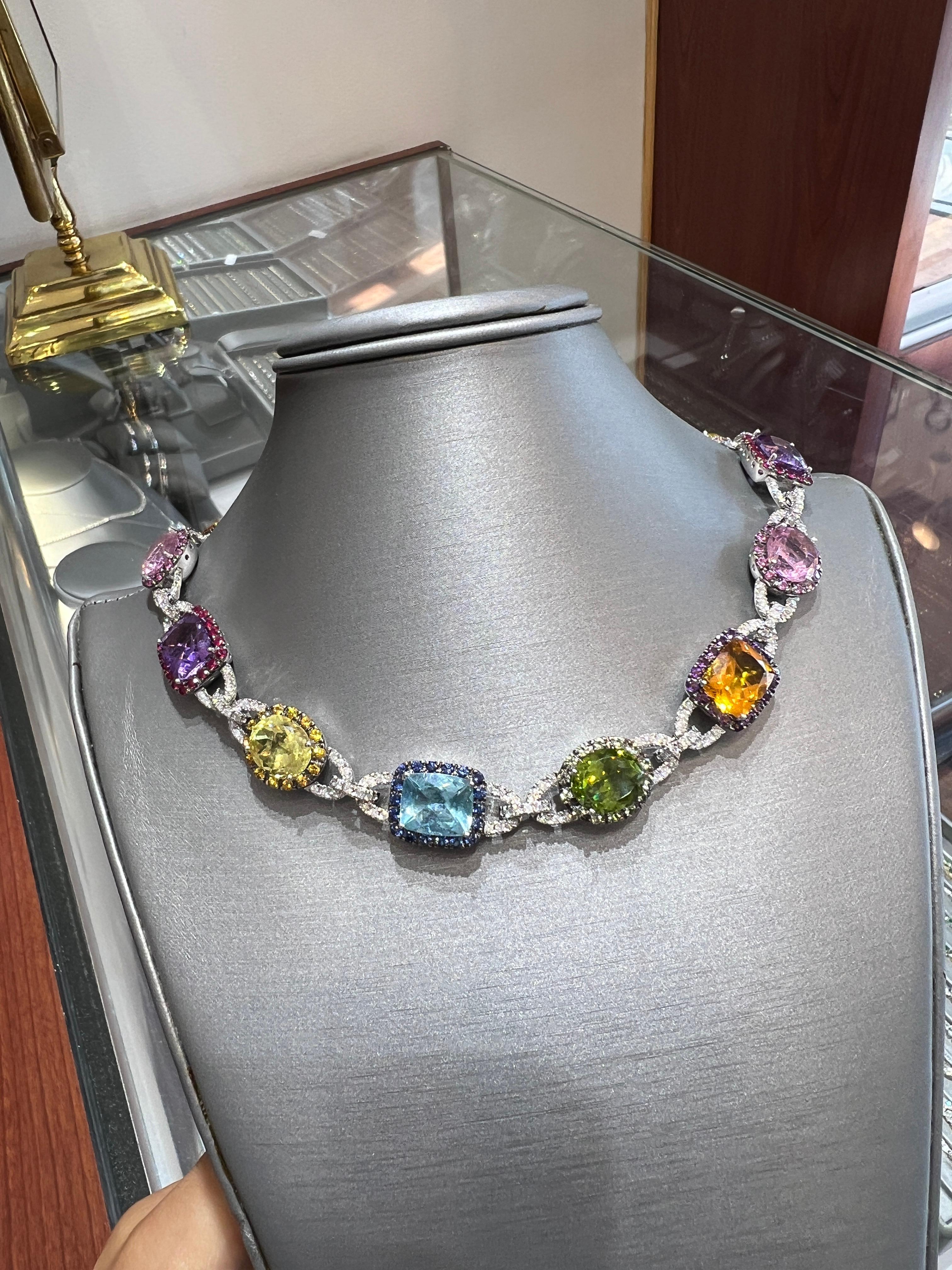 Célébration éclatante de la couleur et de l'artisanat, ce collier en or blanc massif 14 carats présente un cercle complet de pierres précieuses topazes multicolores naturelles dans des teintes audacieuses de bleu, vert, jaune, rose, violet et