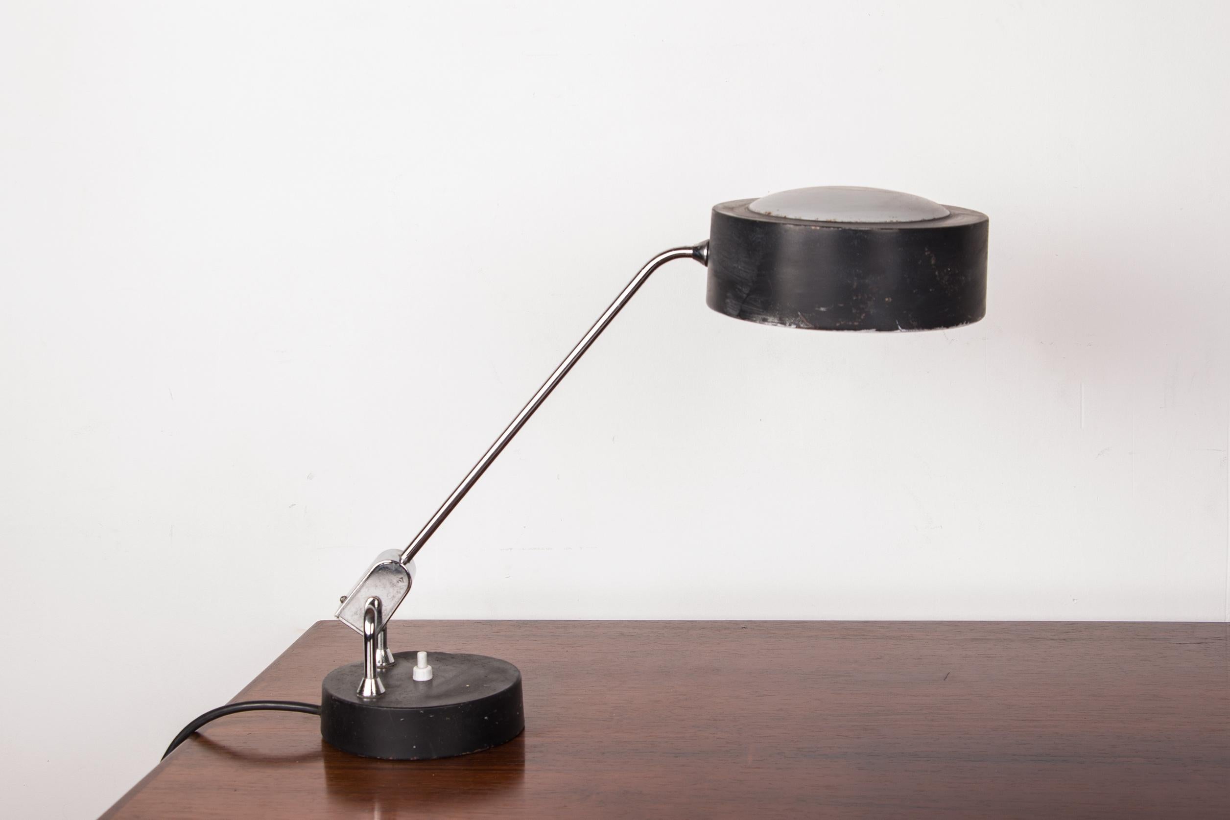 Pretty large desk lamp with articulating arm that allows you to adjust the direction of the light. Light cover and base on spherical base.
