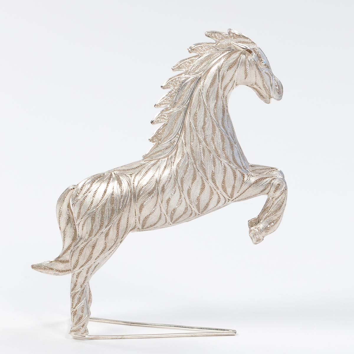 This sculpture in 925 silver of a Jumping Horse is a true masterpiece of filigree technique.
Filigree comes from the Latin and consists of 2 words filum (thread) and granum (grain).
With the filigree technique, jewelry and objects are made from