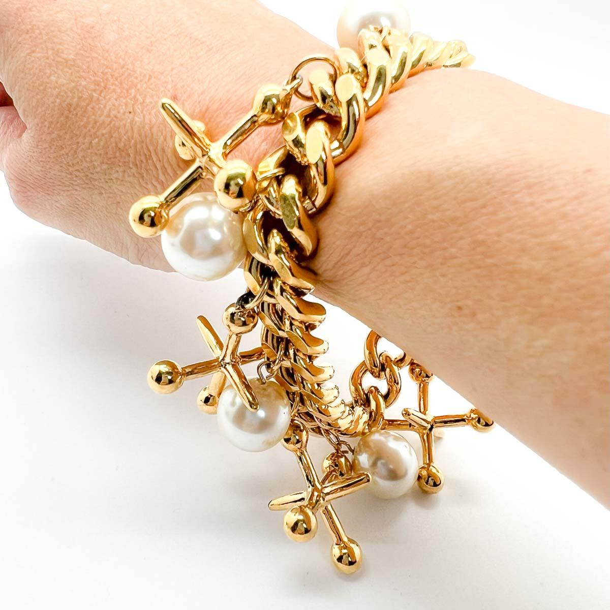 Our Jumping Jacks Charm bracelet. Playful fun abounds with a chunky chain embellished with jumping jack charms and a timeless pearl finish. A ultra cool statement piece.
Vintage Condition: Very good without damage or noteworthy wear.
Materials: Gold