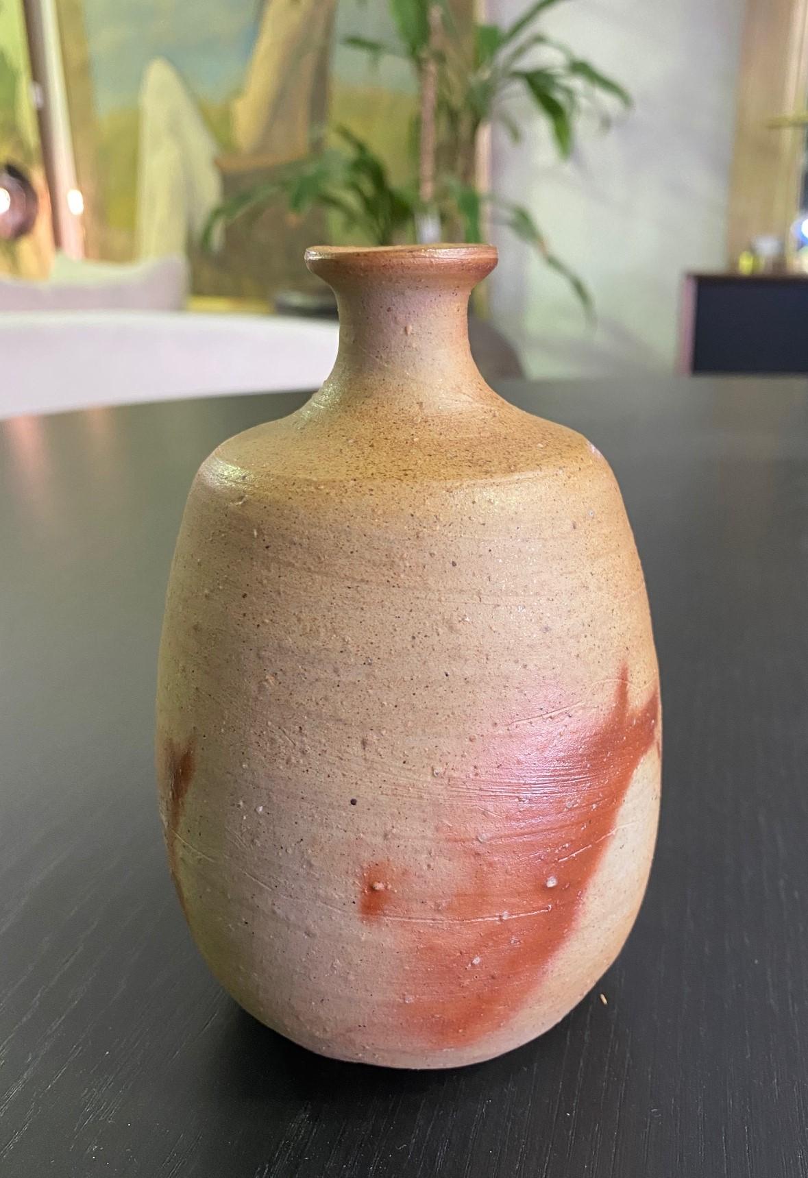 A wonderfully made pottery bottle/vase by famed Japanese Bizen ware master artist Jun Isezaki who was named a Japanese Living National Treasure. 

Beautiful, exquisite form, and glowing Bizen rich color. 

The work is signed by Isezaki on the