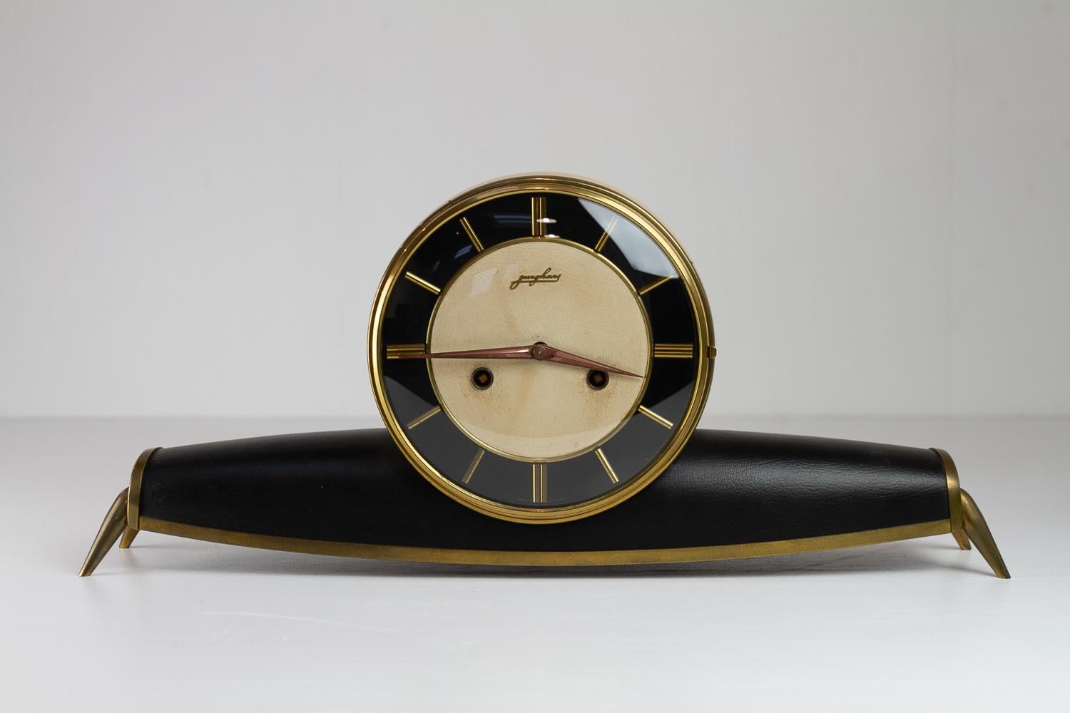 Junghans Mid-Century Modern Mantel Clock, 1950s.
Very elegant Mid-Century modern mantel clock made by Junghans in the 1950s with design elements from Art Deco. White and black faux leather and brass frame and legs.
Lovely chime, which is easily