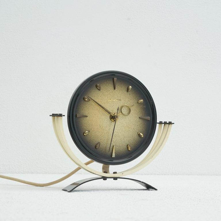 Junghans mid-century table clock in metal and brass. Germany, 1950s    Decorative and elegant mid century table clock made by renowned clock maker Junghans. A very delicate and joyful design, this clock is quintessentially mid century. The