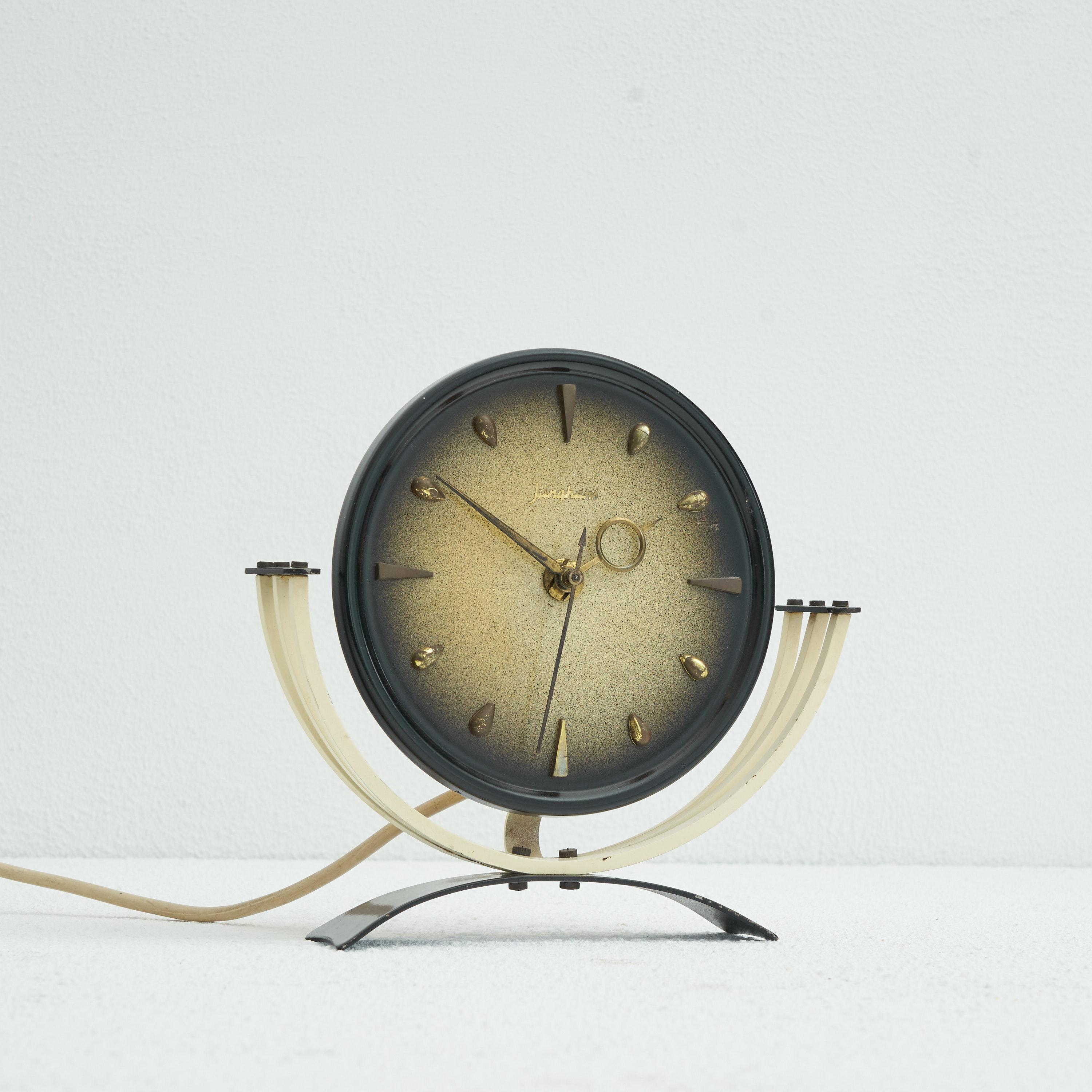 Horloge de table Junghans du milieu du siècle en métal et laiton. Allemagne, années 1950

Horloge de table décorative et élégante du milieu du siècle dernier, fabriquée par le célèbre horloger Junghans. D'un design très délicat et joyeux, cette