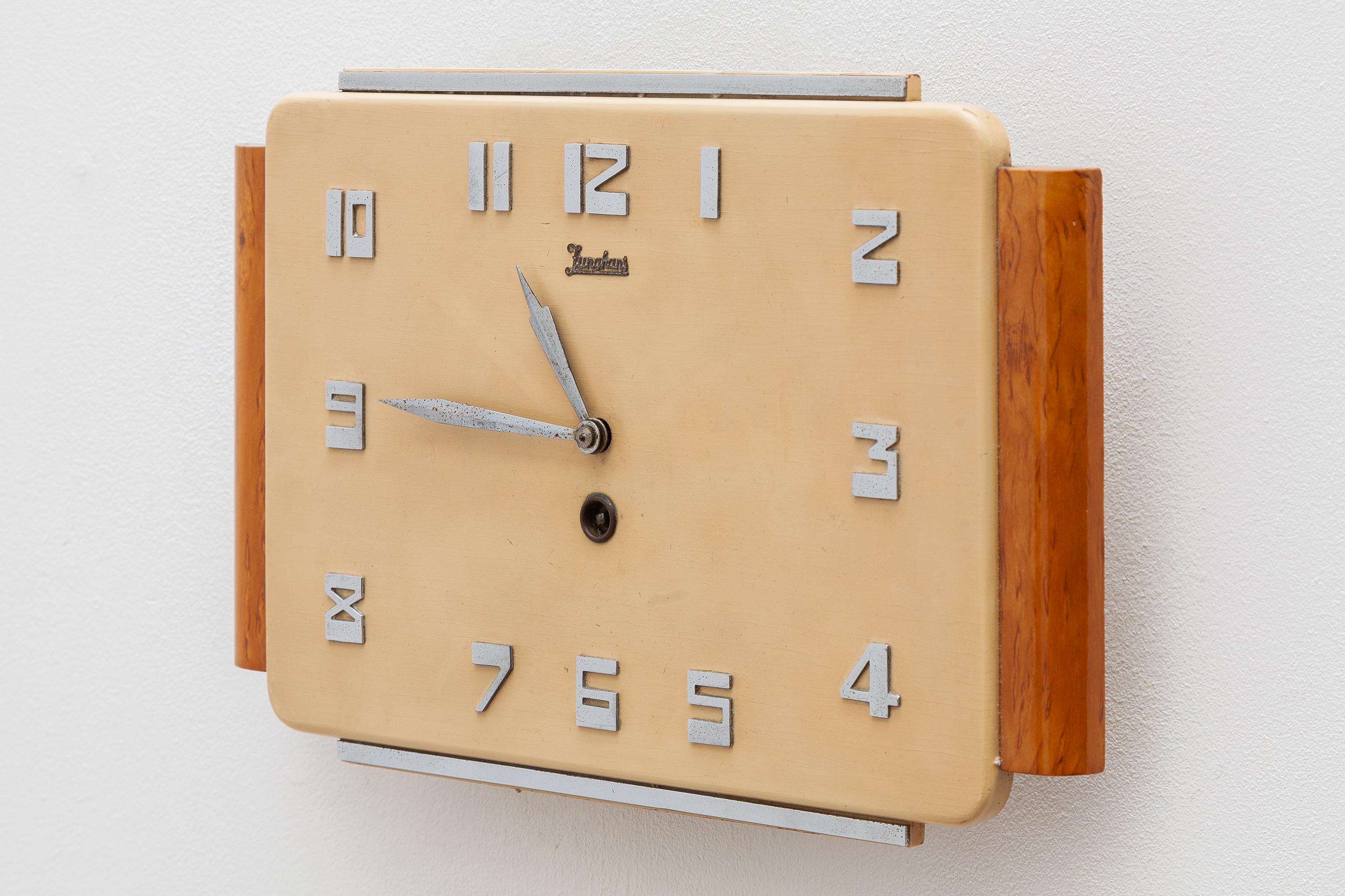 Art Deco wall clock by famed German watch and clockmaker, Junghans. In wood, celluloid and chrome elements.
Dimensions: 32 W x 20 H x 5 D cm.
Working good condition.