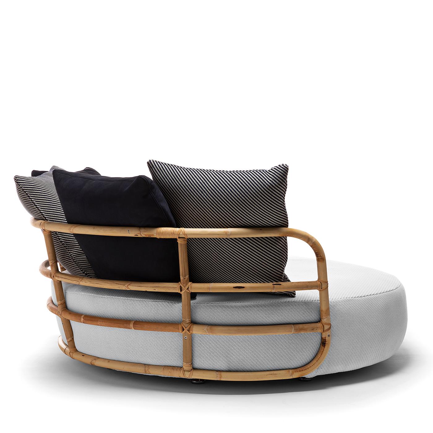 Extraordinarily welcoming in its simple, rounded shape, this daybed by Massimo Castagna can be enjoyed alone or in company thanks to its large size. Boasting a splendid backrest made of a bamboo cane, it features a softly padded cushion upholstered