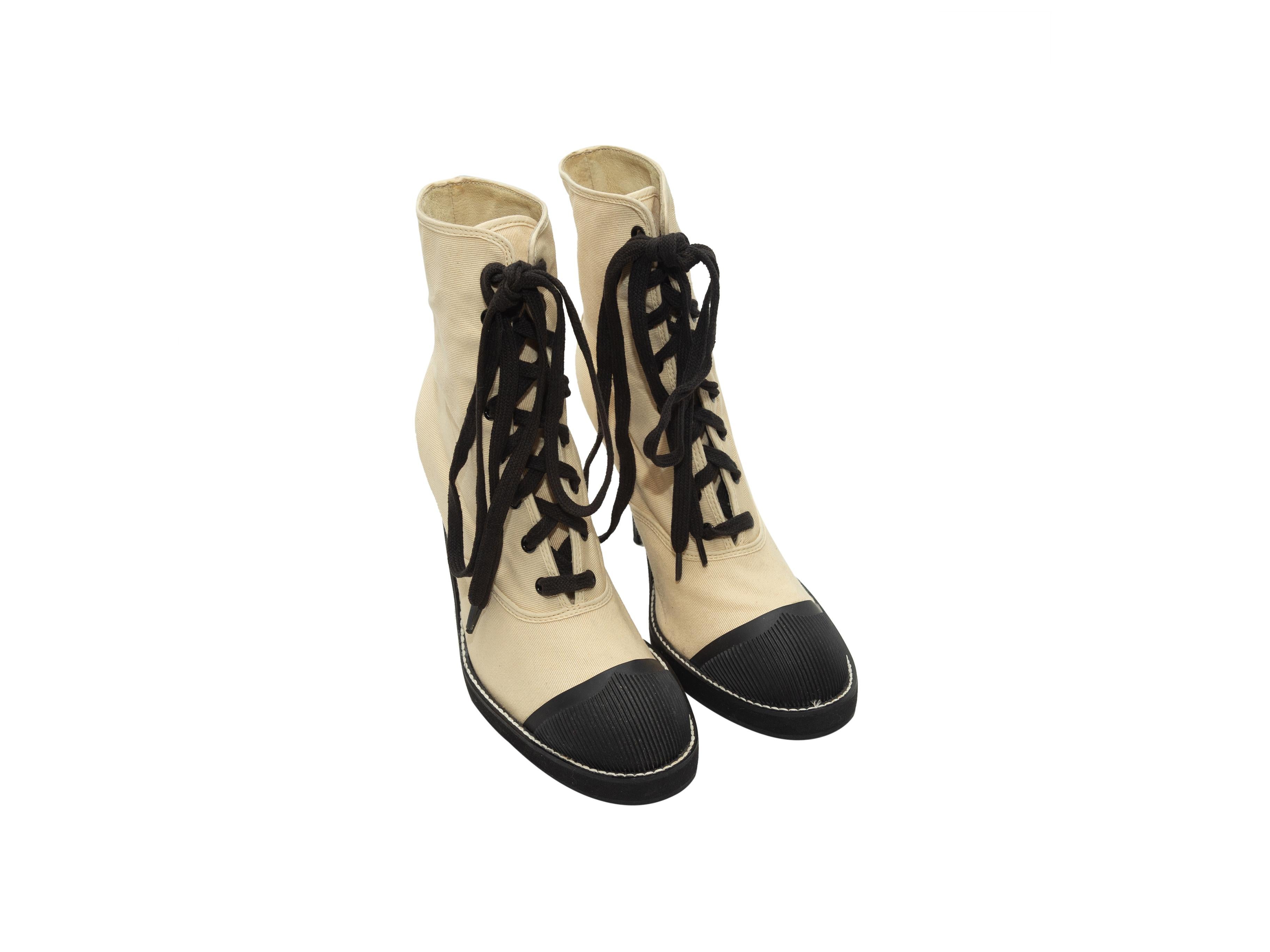Product details: Vintage cream canvas and black rubber cap-toe booties by Junior Gaultier. Stacked heels. Lace-up tie closures at tops. Designer size 37. 4