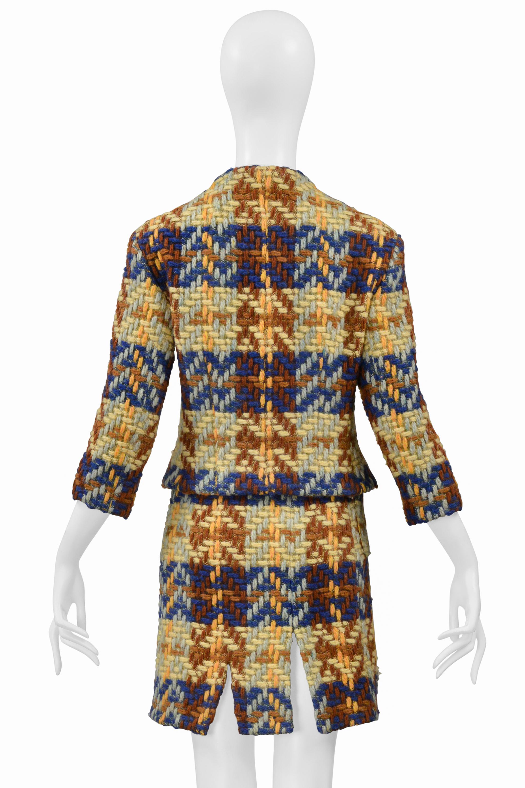 Resurrection Vintage a le plaisir de vous proposer un tailleur jupe vintage Junko Shimada en laine bleue, marron et jaune avec un imprimé écossais, des boutons noirs surdimensionnés sur le devant de la veste, des manches courtes, un col légèrement